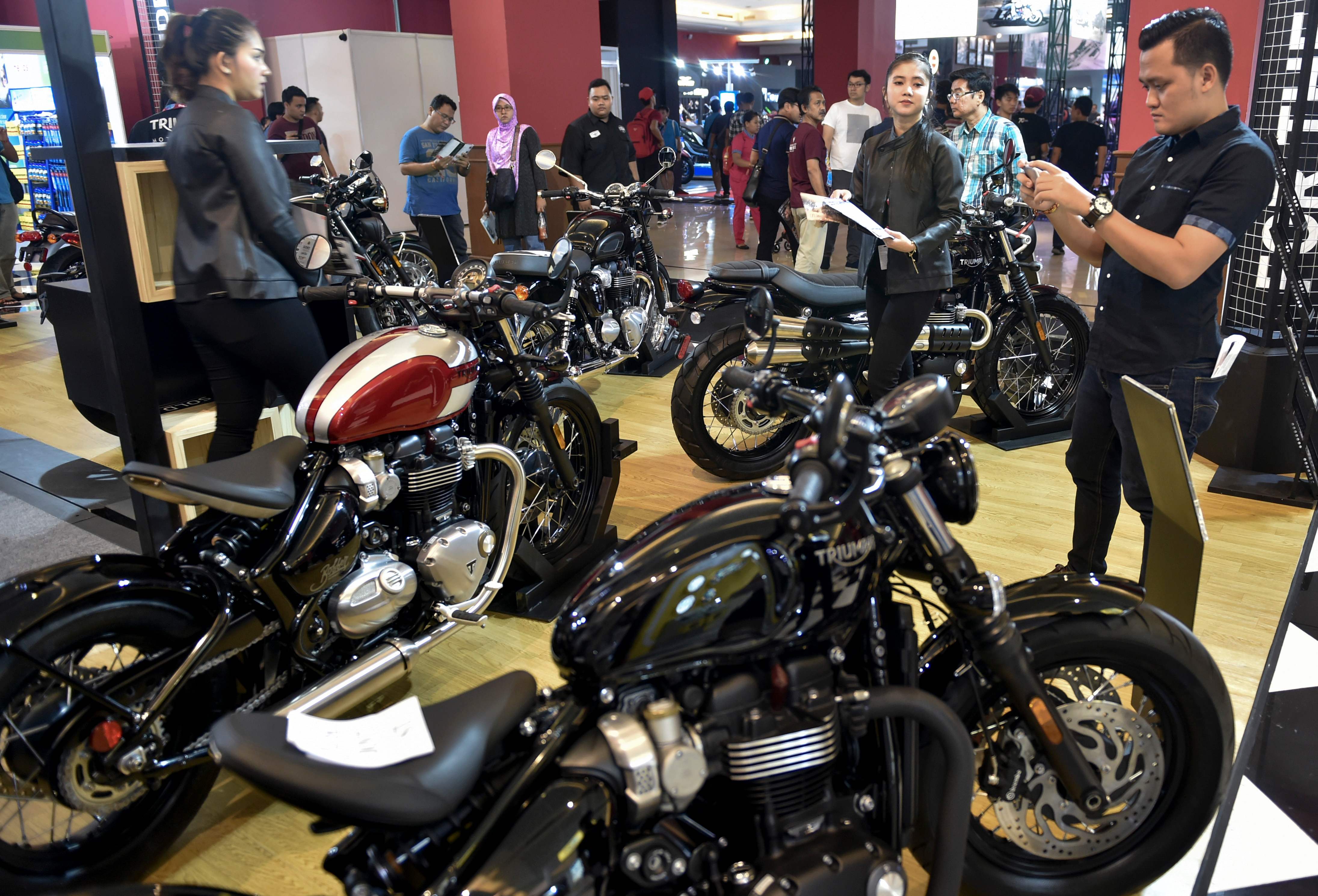 Orang-orang mengunjungi stan sepeda motor Triumph selama 2018 Indonesia International Motor Show 