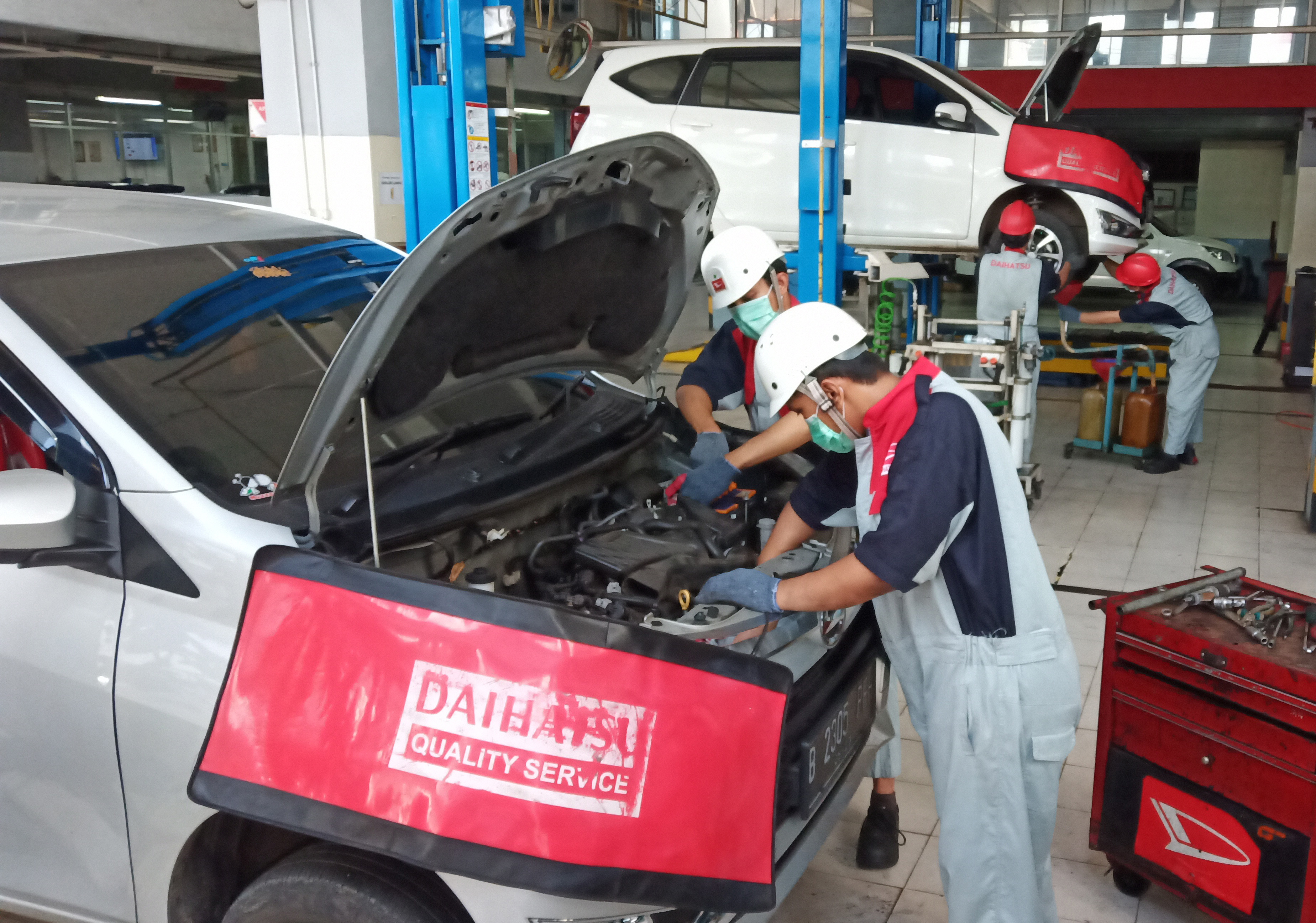 Mekanik sedang merawat kendaraan konsumen di bengkel resmi Daihatsu di Sunter, Jakarta Utara.