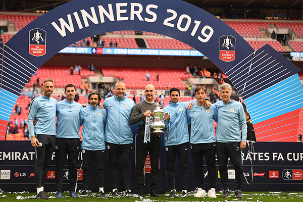 Pelatih Manchester City Pep Guardialo memegang trofi Piala FA