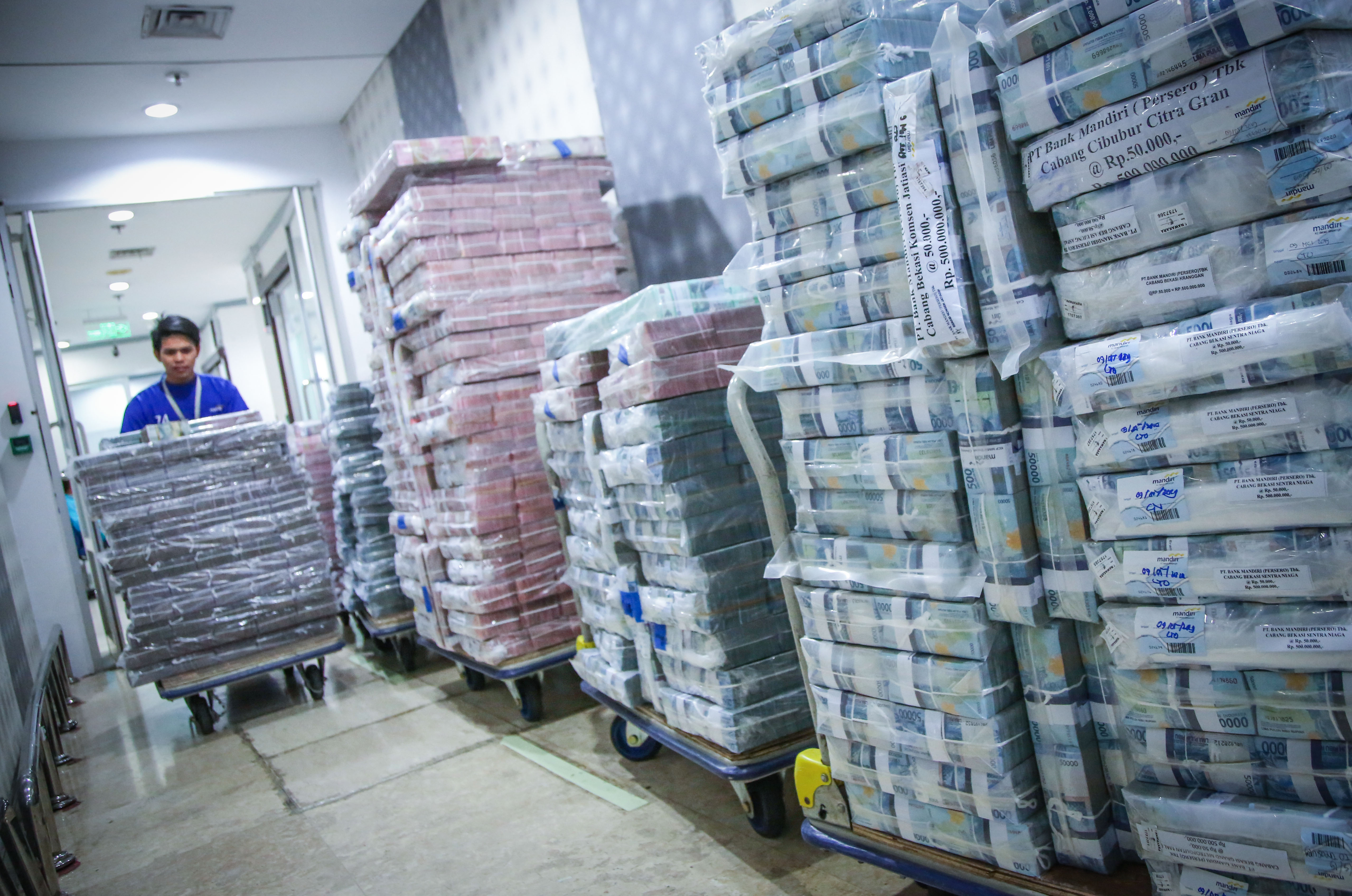 Petugas memindahkan pasokan uang di Cash Pooling Bank Mandiri, Jakarta, Kamis (9/5/2019).
