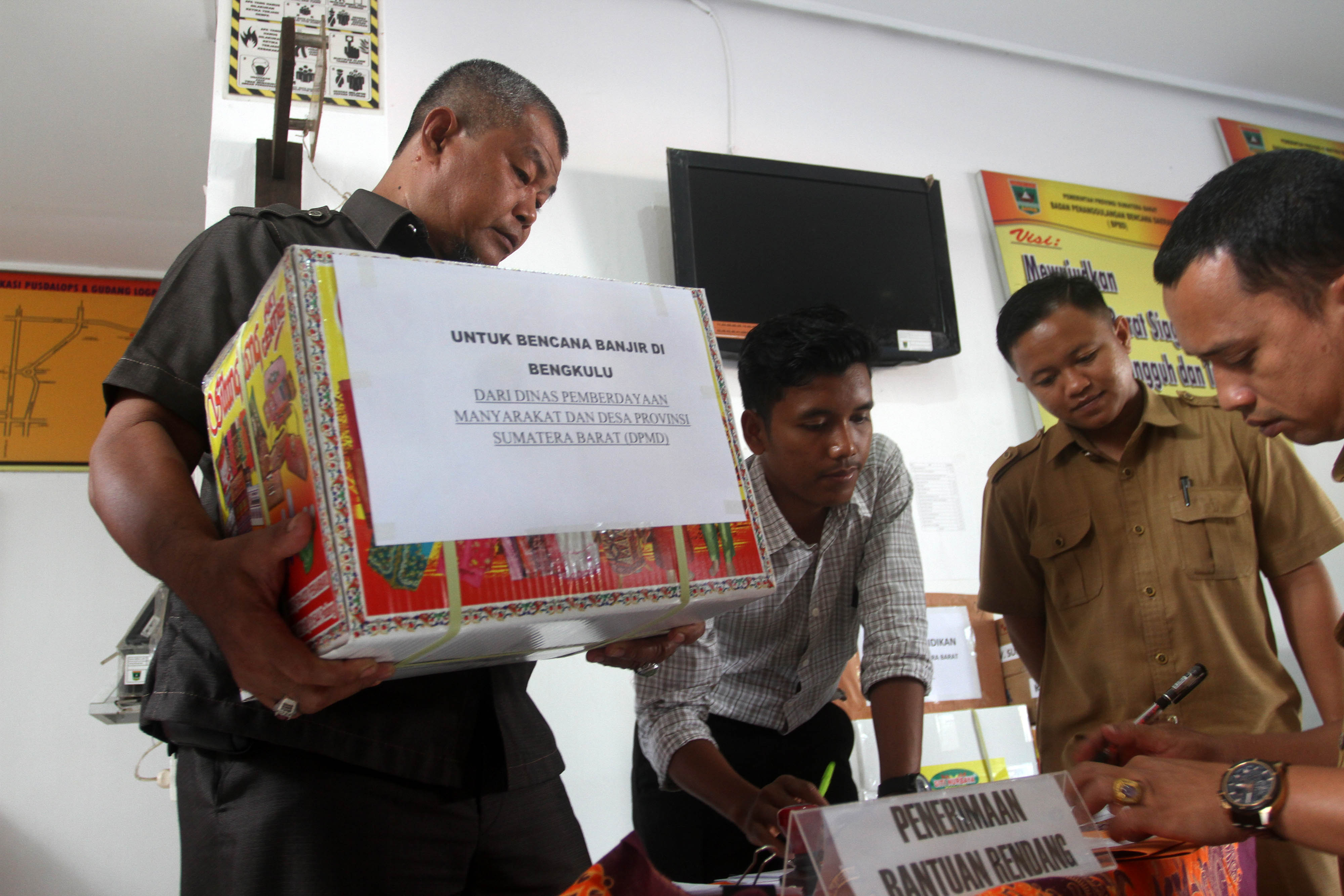 Petugas Badang Penangulangan Bencana Daerah (BPBD) Sumatera Barat mengangkat kardus yang berisikan rendang di Padang, Sumatera Barat