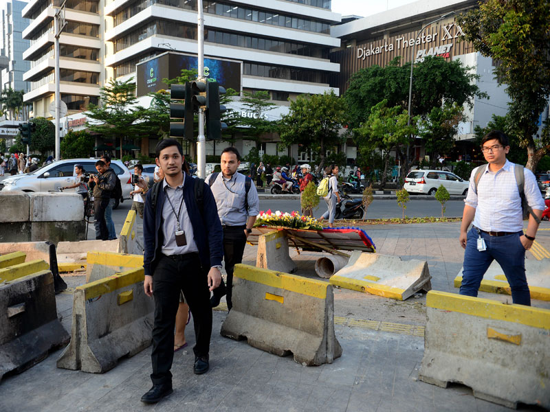 Masyarakat dan pekerja melintasi pembatas jalan setelah sebelumnya kawasan Gedung Bawaslu dan sekitarnya di blokir di Thamrin, Jakarta.