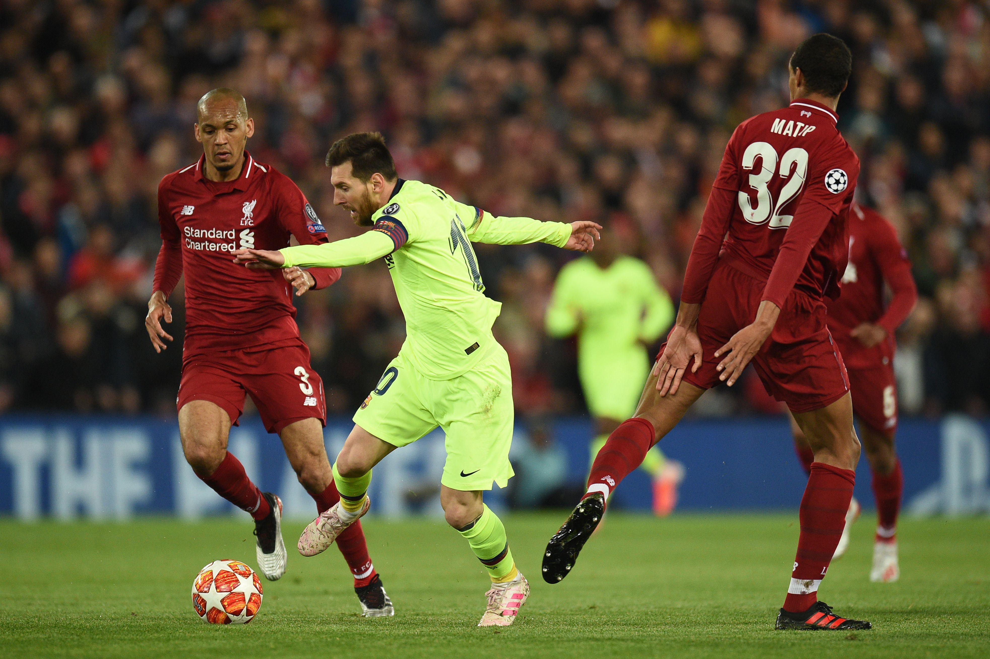 Striker Barcelona Lionel Messi (tengah) dari Barcelona melompati pemain tengah Liverpool asal Brasil Fabinho (kiri) 