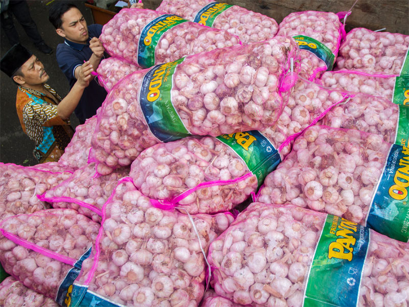 Warga mengambil bawang putih yang dijual saat operasi pasar bawang putih di Pasar Kosambi, Bandung, Jawa Barat (10/5/2019).