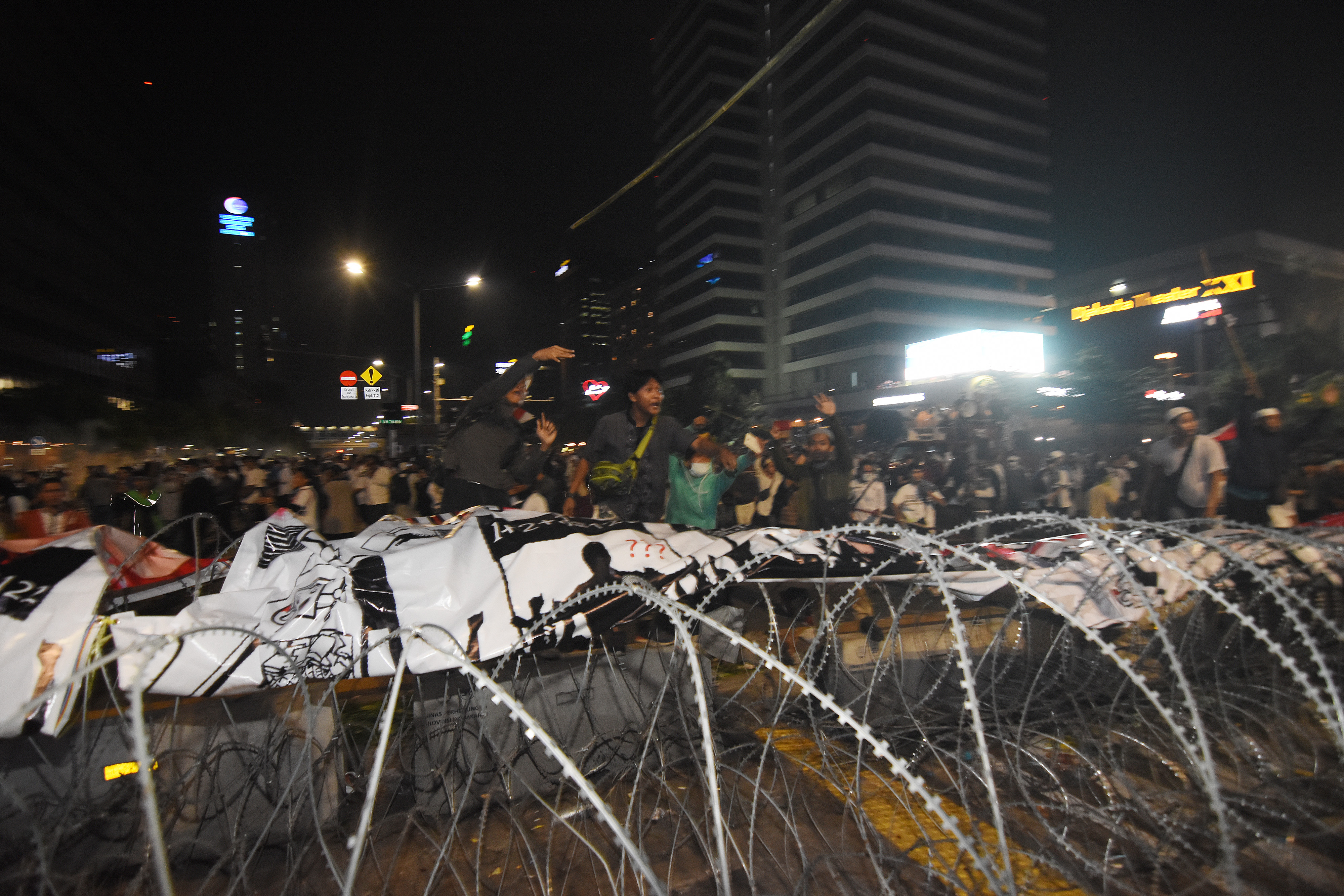 Polisi berjaga di belakang barikade saat mengawal demonstrasi 22 Mei