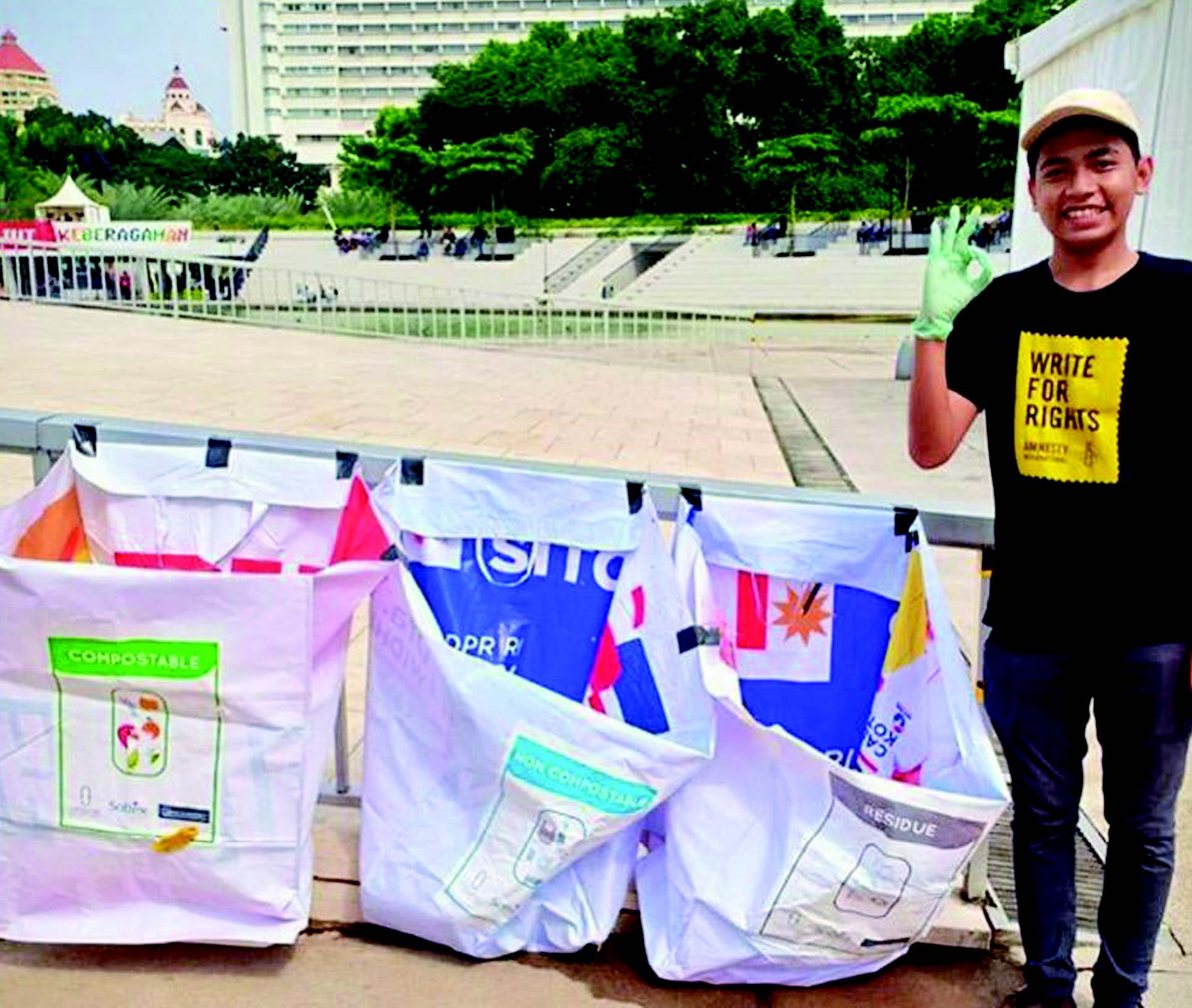 Seorang anggota Parongpong Recycle and Waste Management, berdiri di samping kantong sampah yang dibuat dari bekas spanduk kampanye