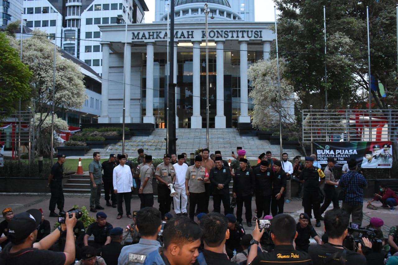 Suasana aksi simpatik para pendekar NU dengan aparat TNI-Polri dalam buka puasa bersama di depan Gedung Mahkamah Konstitusi, hari ini.