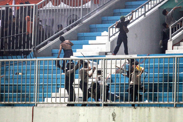 Polisi menghalau pendukung yang ricuh saat pertandingan Liga 1 antara PSS Sleman melawan Arema FC di Stadion Maguwoharjo, Sleman, 