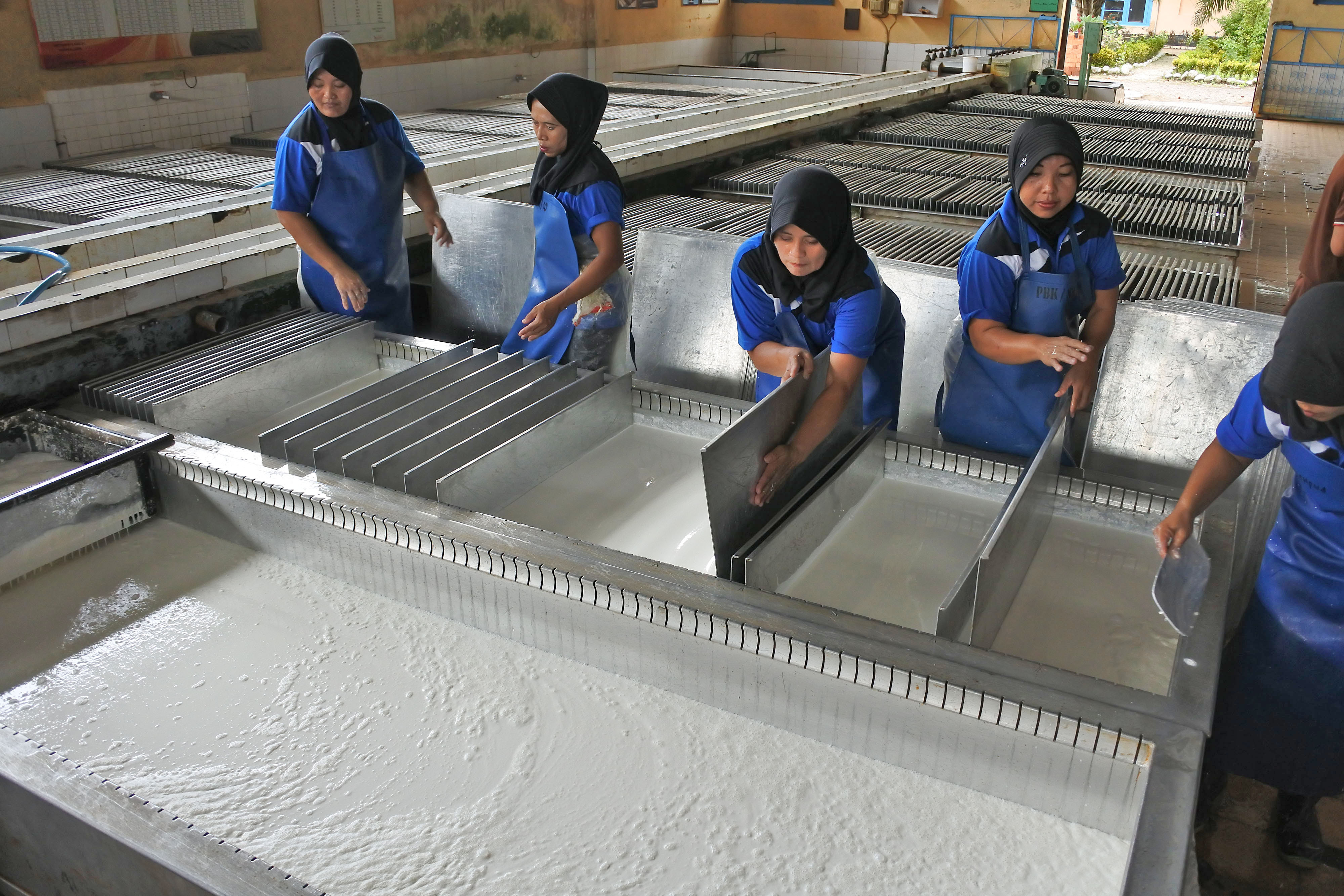 Sejumlah pekerja mengolah karet di pabrik pengolahan karet Kebun Glantangan milik PTPN XII, di Tempurejo, Jember, Jawa Timur.