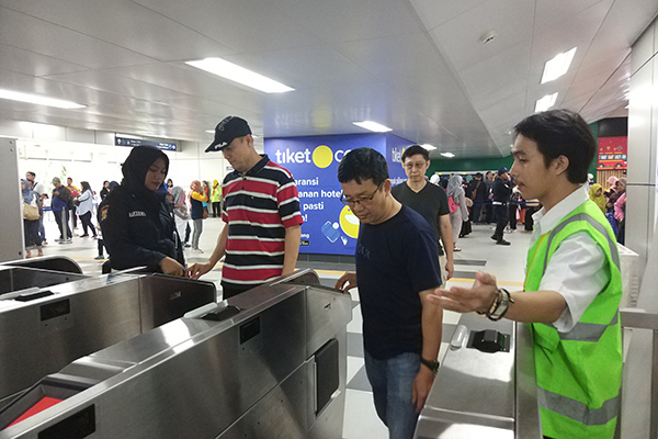 Penumpang melakukan tap in di gate MRT Stasiun Lebak Bulus