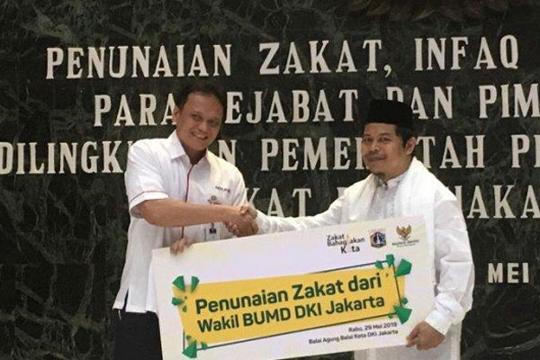 Direktur Teknologi & Operasional Bank DKI, Priagung Suprapto, menyerahkan secara simbolis, ZIS Bank DKI kepada Ketua Baznas Bazis DKI 
