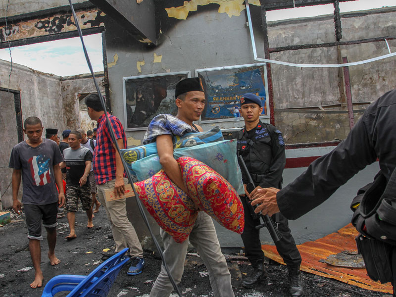  Sejumlah narapidana mengikuti proses pemindahan dengan pengawalan kepolisian pascakerusuhan yang terjadi di Rutan Kelas IIB Siak 