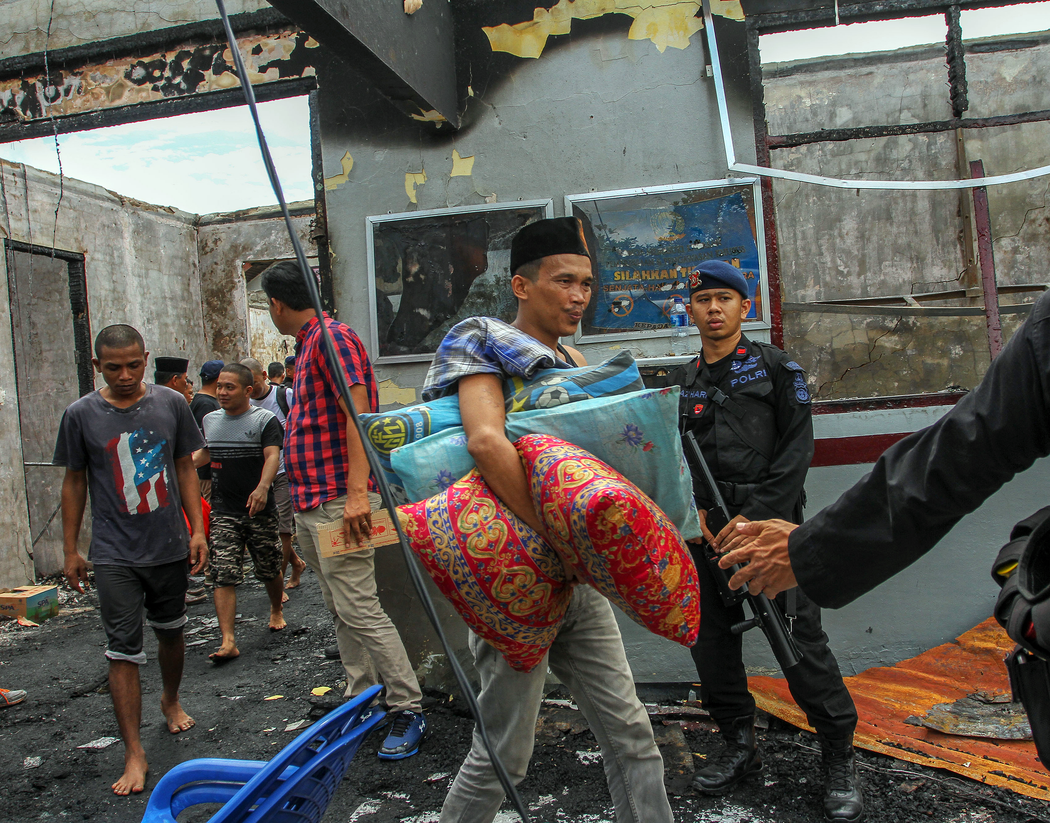 Sejumlah narapidana mengikuti proses pemindahan dengan pengawalan kepolisian pascakerusuhan