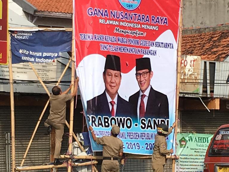 Petugas menurunkan baliho ucapan selamat atas kemenangan pasangan Capres-Cawapres nomor urut 02 Prabowo-Sandiaga Uno di Kota Bekasi.