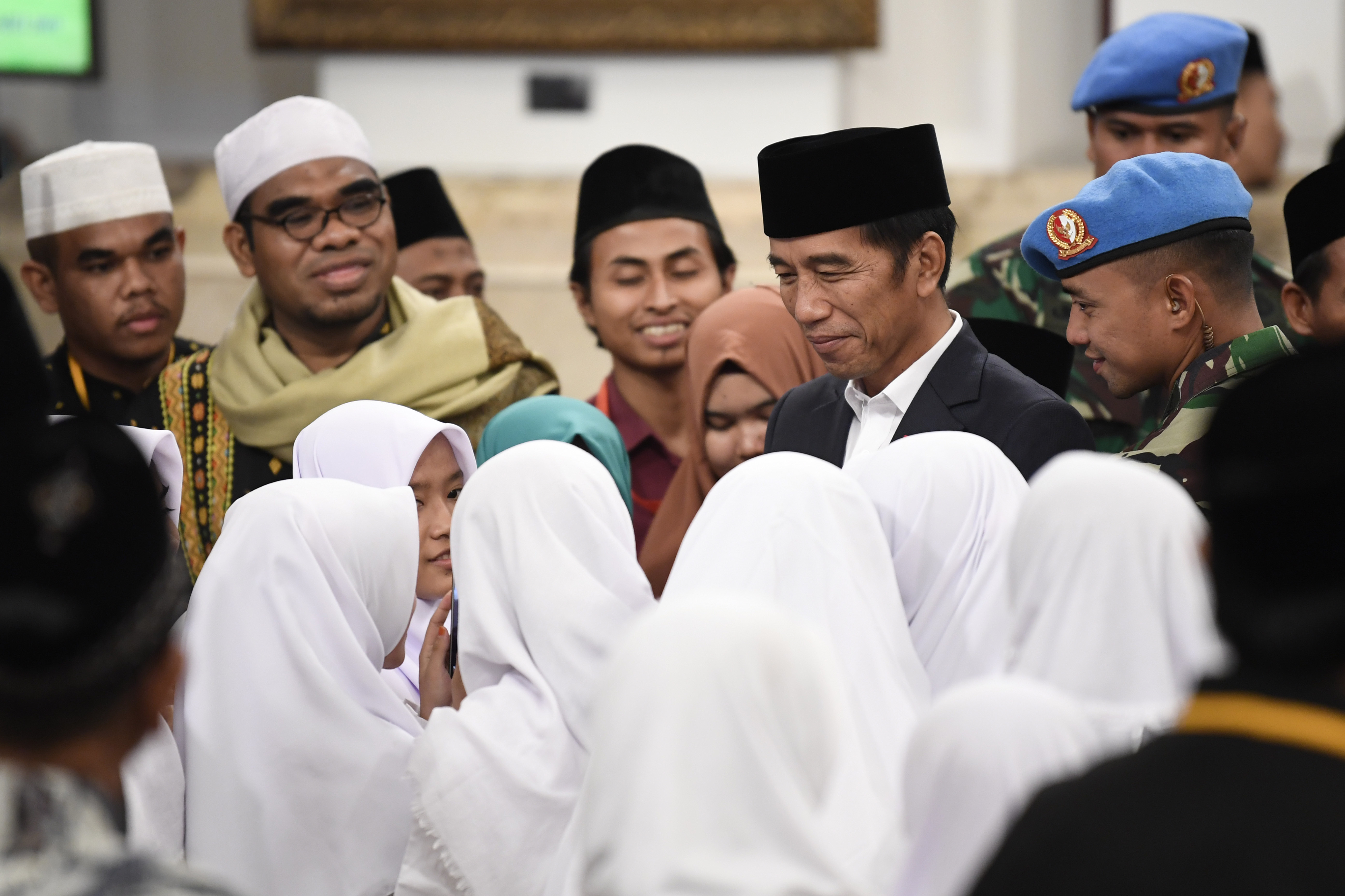Presiden Joko Widodo (tengah) menyapa santri yang hadir dalam peringatan Nuzulul Quran di Istana Negara, Jakarta, Selasa (21/5/19).