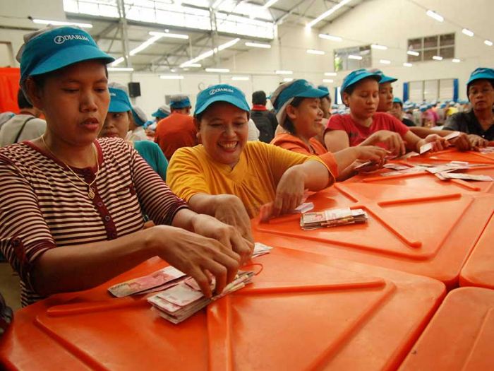  Buruh linting rokok menghitung uang Tunjangan Hari Raya (THR) di pabrik rokok PT. Djarum, Kudus 