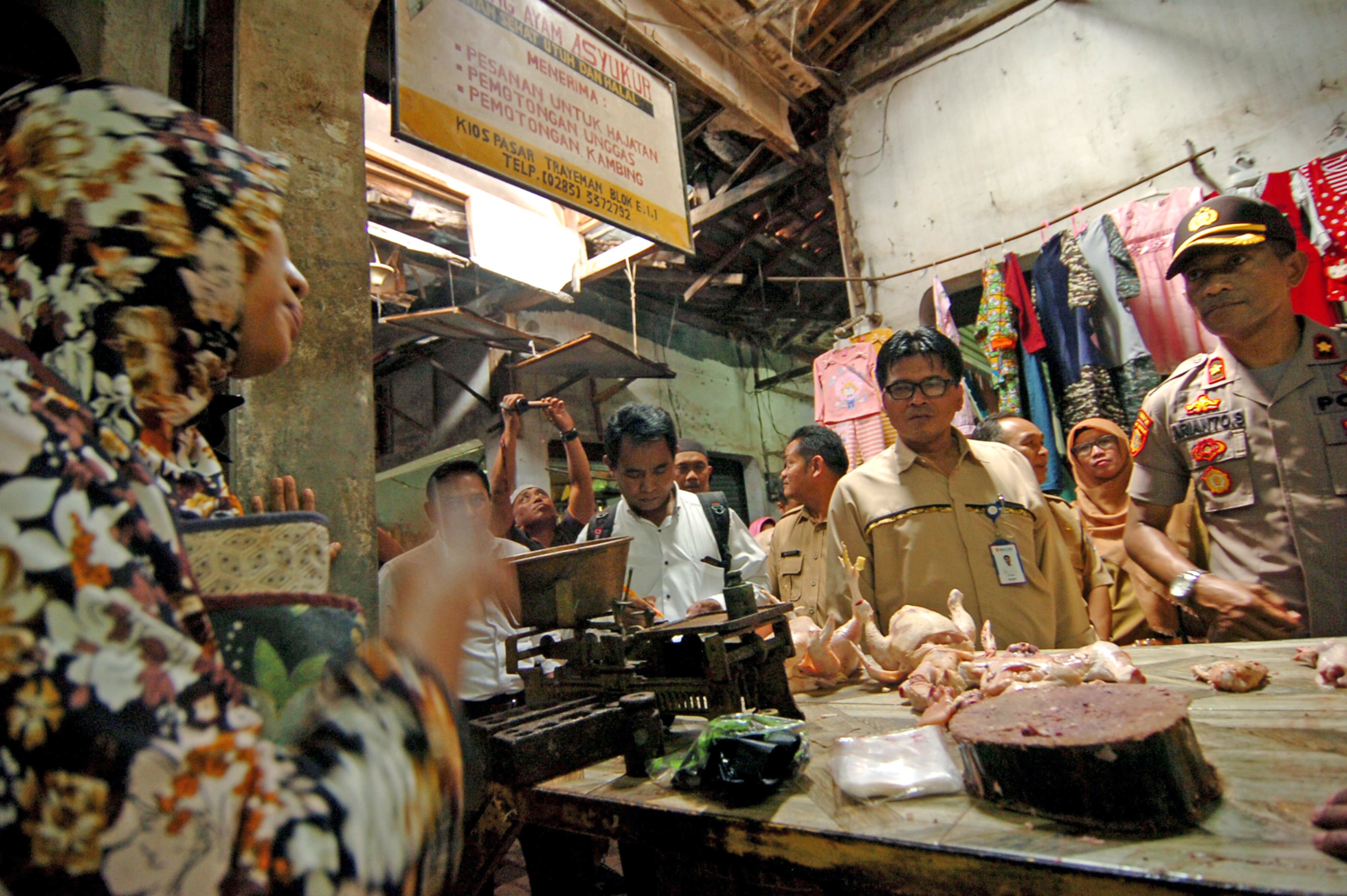 Petugas (kanan) memeriksa harga ayam potong saat sidak pangan 
