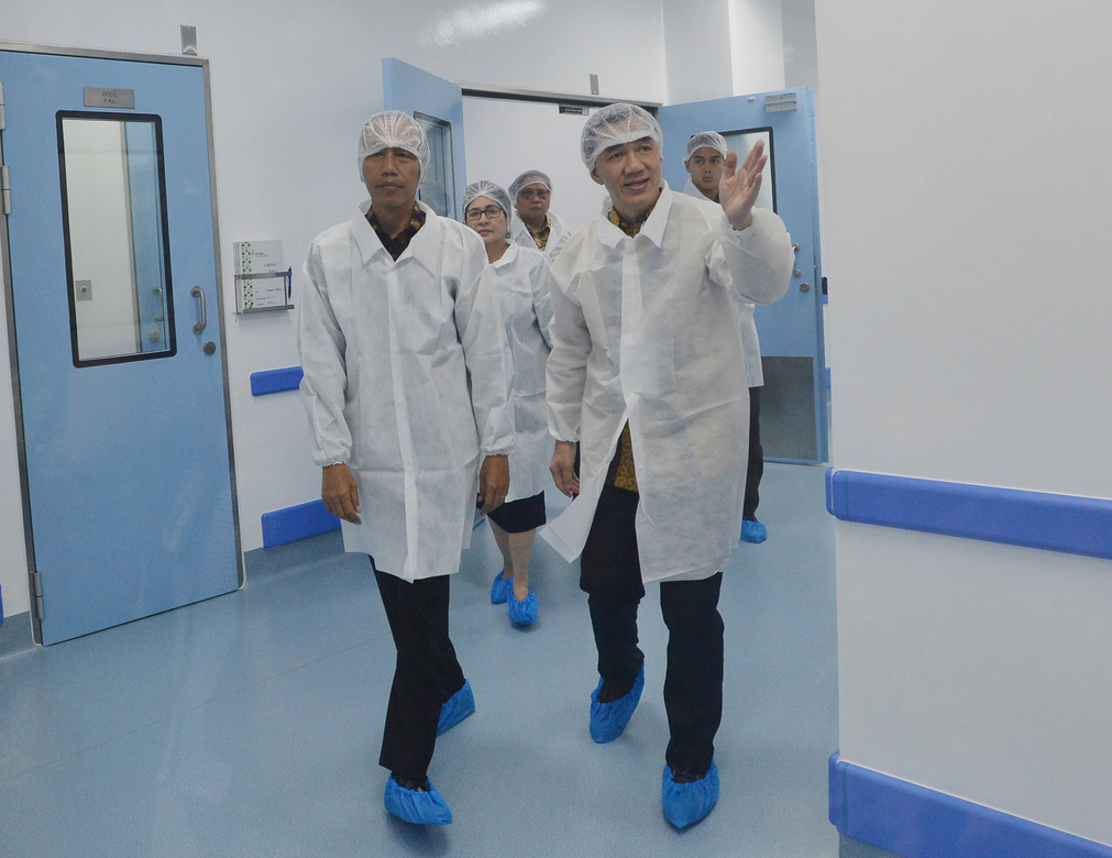 Presiden Jokowi (kiri) mendapat penjelasan dari Presiden Direktur PT Kalbe Farma Tbk, Vidjongtius. 