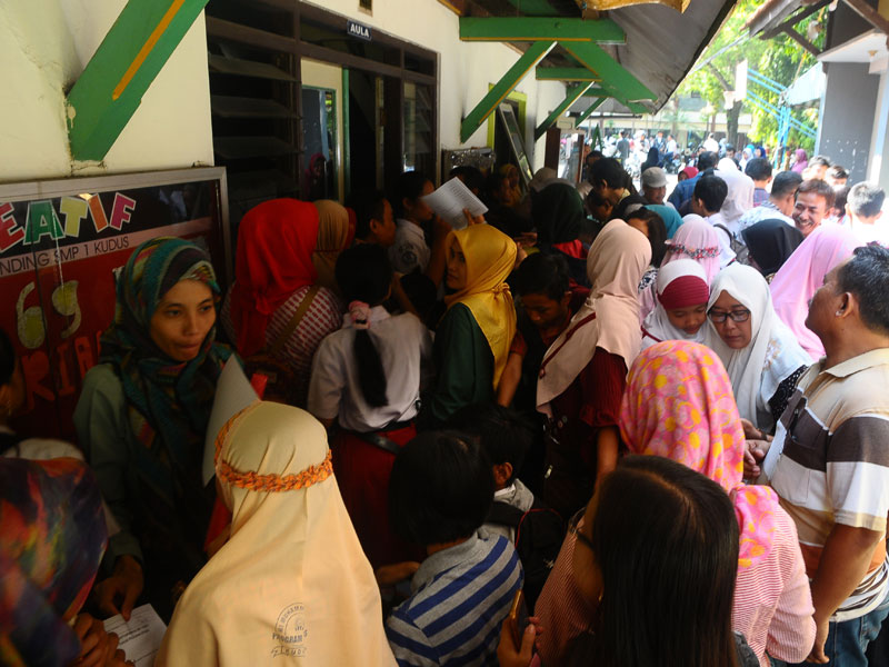 Sejumlah siswa dan orang tua murid antre untuk mengikuti seleksi Penerimaan Peserta Didik Baru (PPDB).