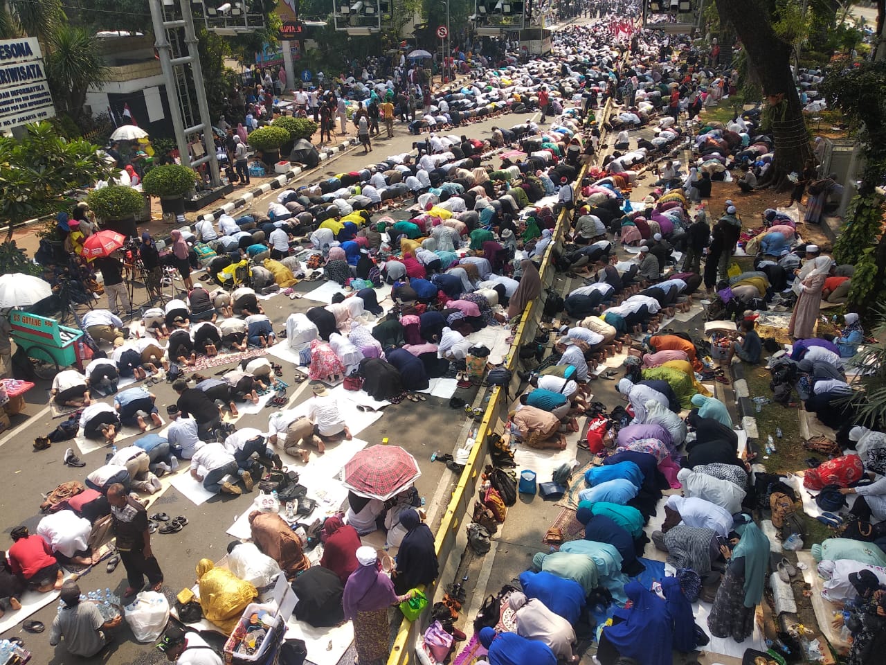 Massa aksi kawal MK melaksanakan salat berjamaah di sepanjang jalan Merdeka Barat, Kamis (27/6)