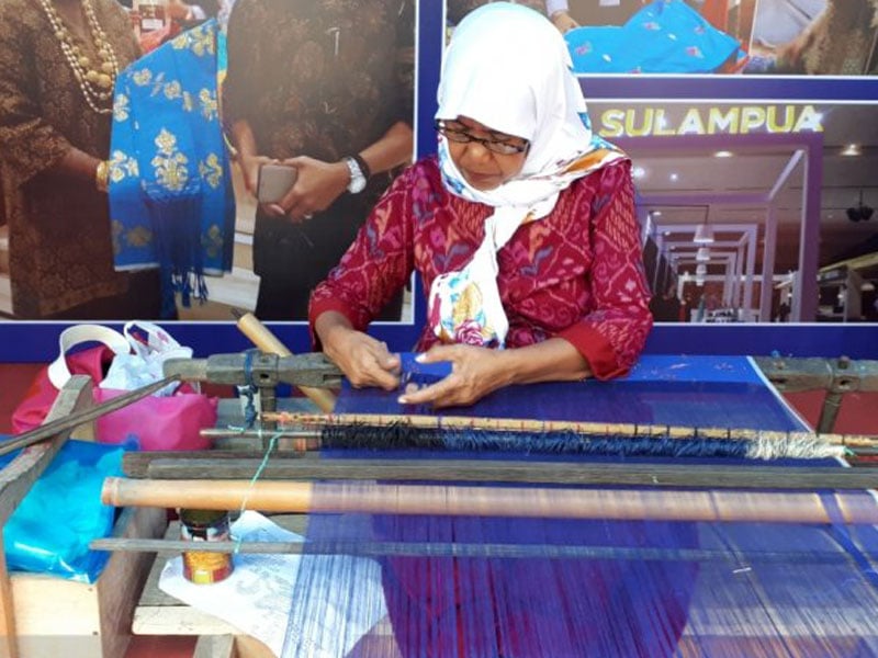 Salah satu pengrajin tenun menunjukkan proses menun kain tenun dari salah satu daerah di Sulawesi Tengah dalam Festival Tenun Sulteng 2019.