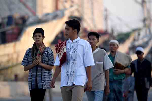 Sejumlah umat Islam berjalan ketika akan melaksanakan shalat Idul Fitri 1 Syawal 1440 Hijriah di kawasan Pelabuhan Sunda Kelapa, Jakarta.