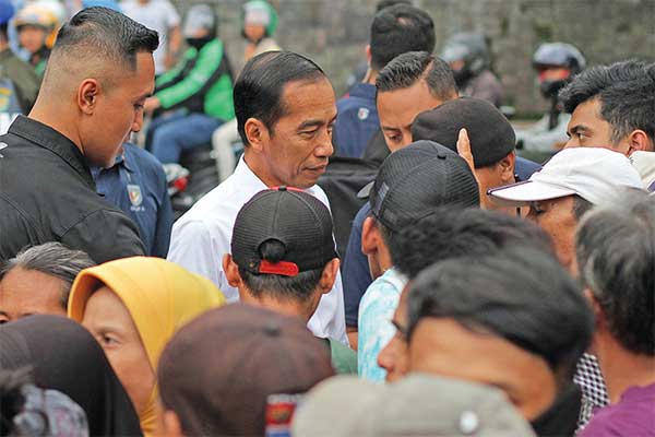 Presiden Joko Widodo  berbincang dengan warga saat pembagian paket sembako di Kelurahan Baranangsiang, Kota Bogor, Jawa Barat, kemarin