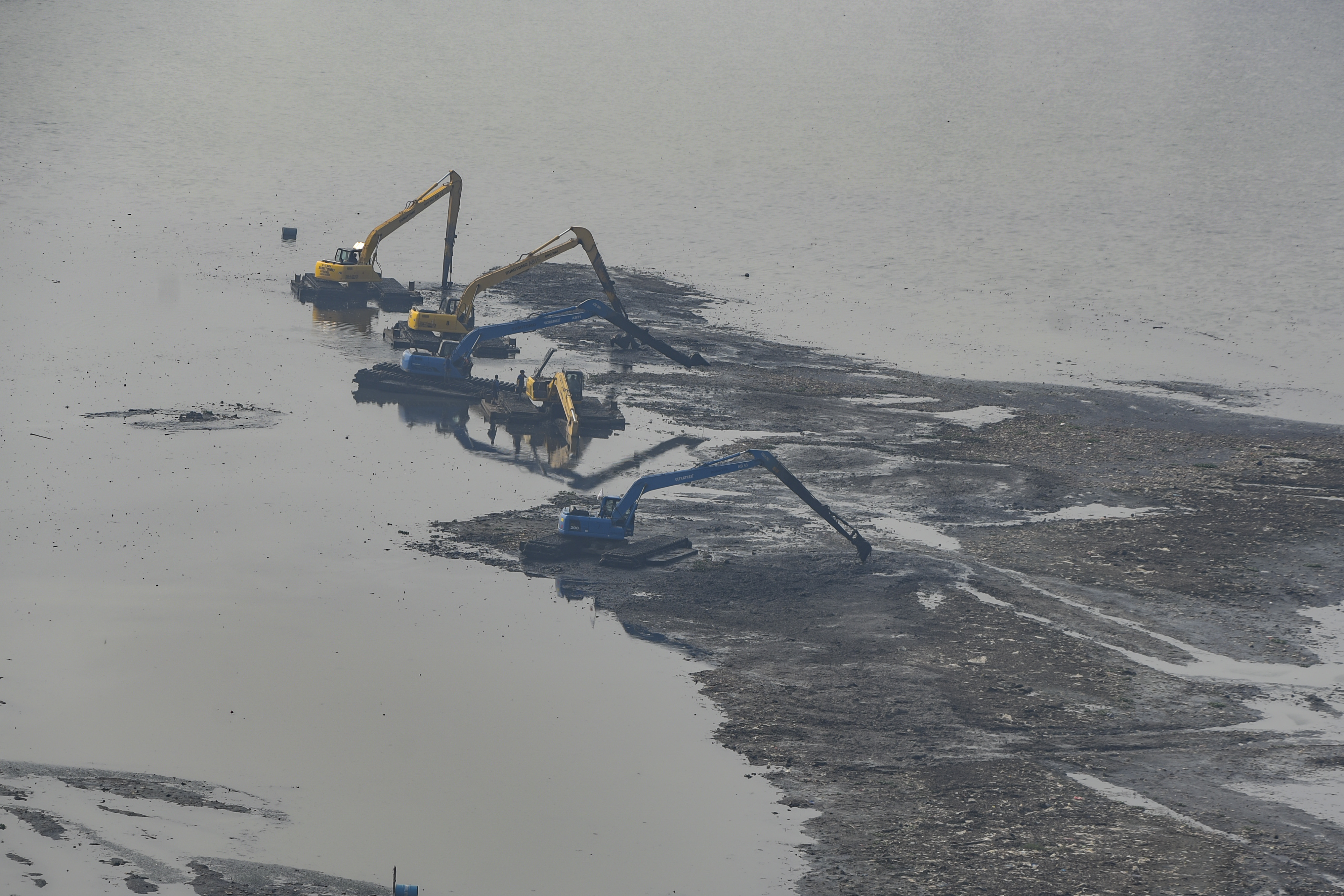Petugas Pemprov DKI Jakarta melakukan pengerukan lumpur di Waduk Pluit, Jakarta