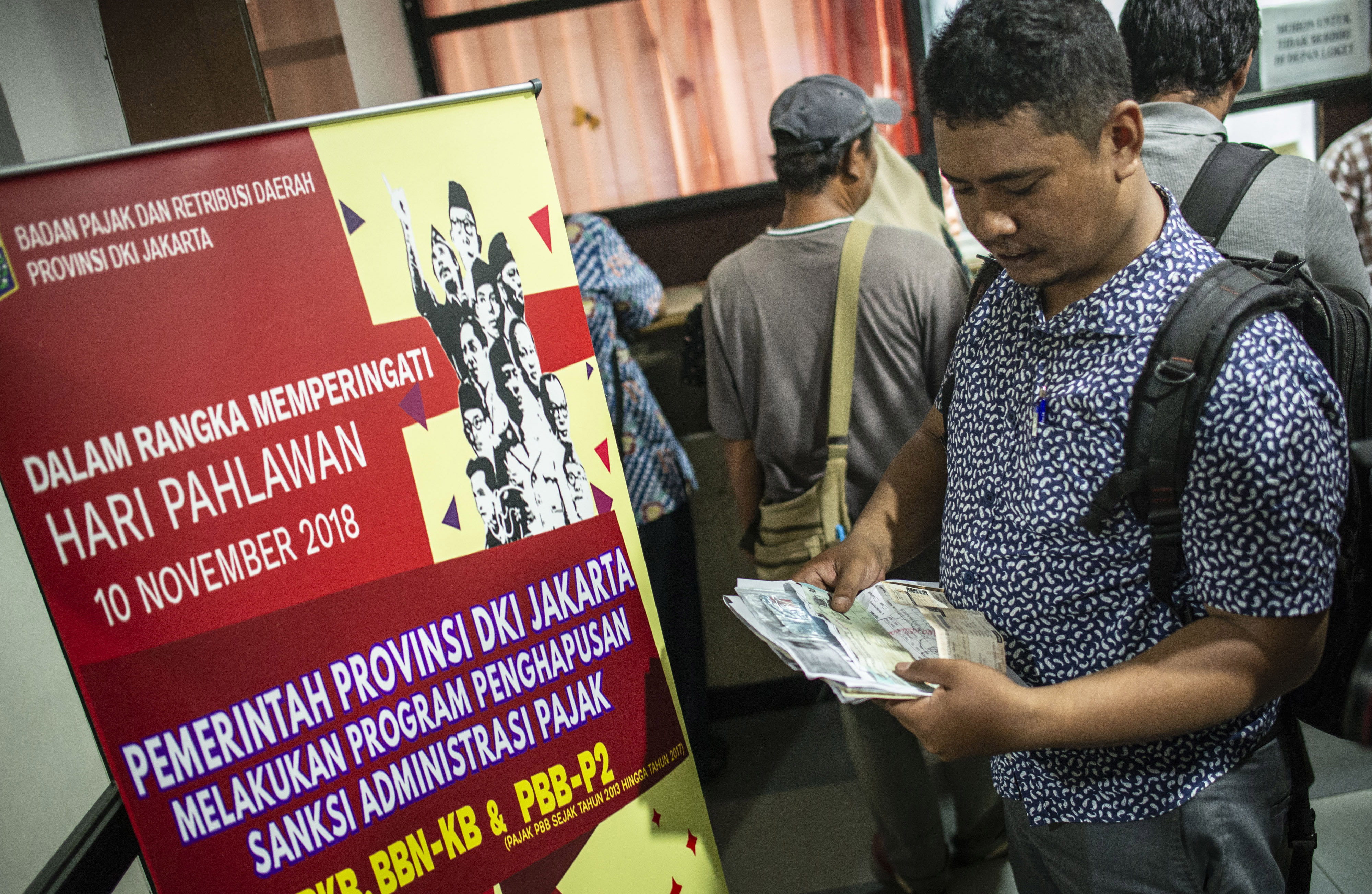 Warga memeriksa dokumen saat melakukan pembayaran pajak kendaraan bermotor di Kantor Samsat Polda Metro Jaya, Jakarta