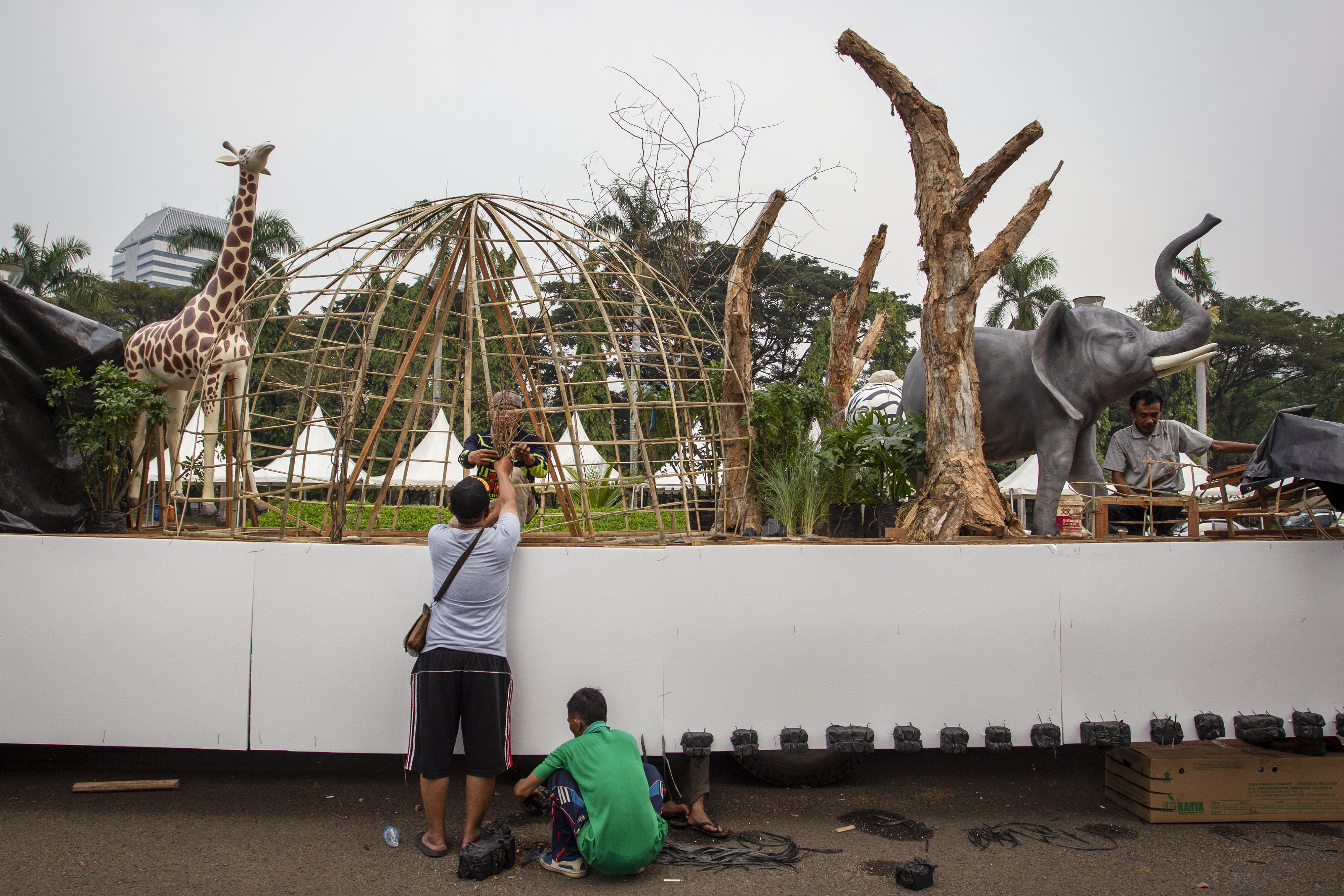 Pekerja menyelesaikan pembuatan kendaraan hias di kawasan Monas, Jakarta, Jumat (28/6). 