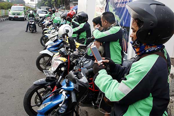 Pengemudi ojek daring (online) menunggu penumpang di depan Stasiun Pasar Minggu, Jakarta, Selasa (11/6).