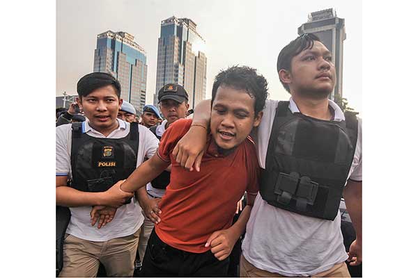 Petugas kepolisian mengamankan seorang pria saat berlangsungnya aksi unjuk rasa kawal sidang sengketa Pilpres 2019 di kawasan Jalan Medan Me