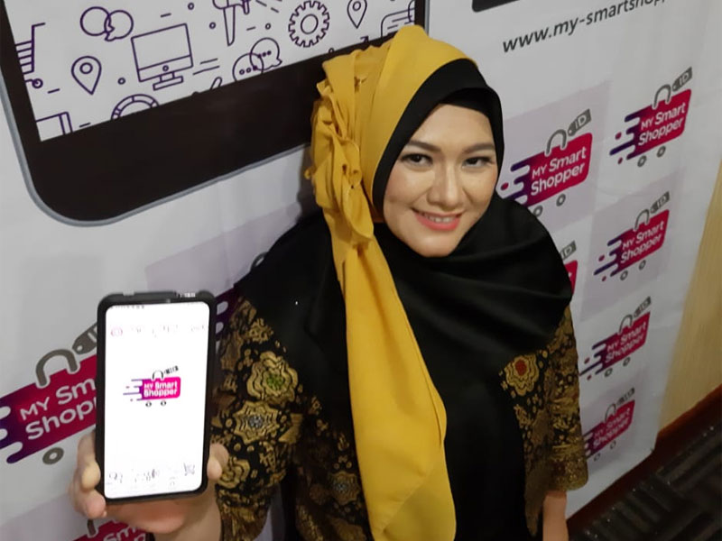 Seorang konsumen menunjukkan fitur aplikasi berbelanja online MY Smart Shopper. 