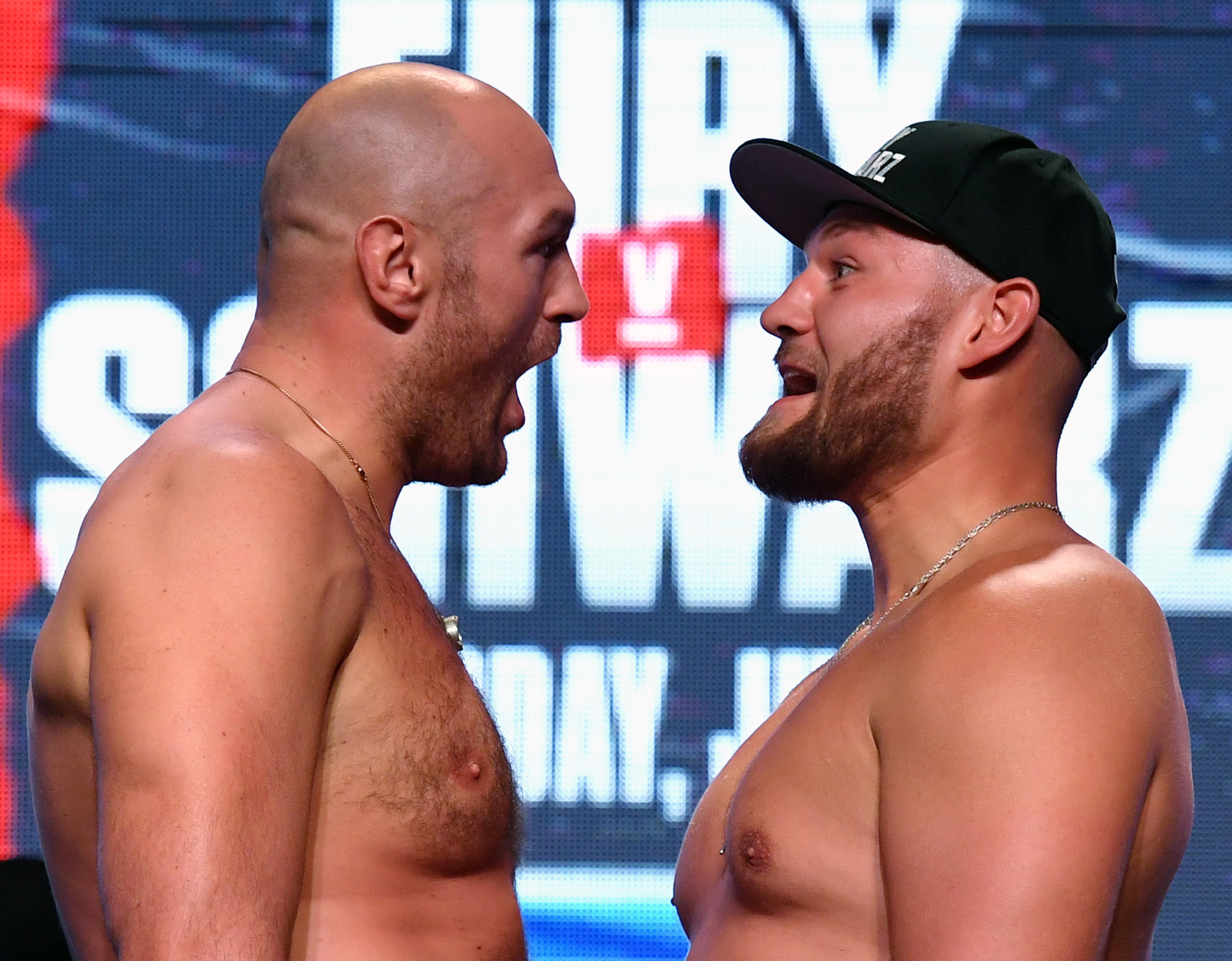 Tyson Fury (kiri) dan Tom Schwarz saling berhadapan saat upacara penimbangan di MGM Grand Garden Arena pada 14 Juni 2019 di Las Vegas,