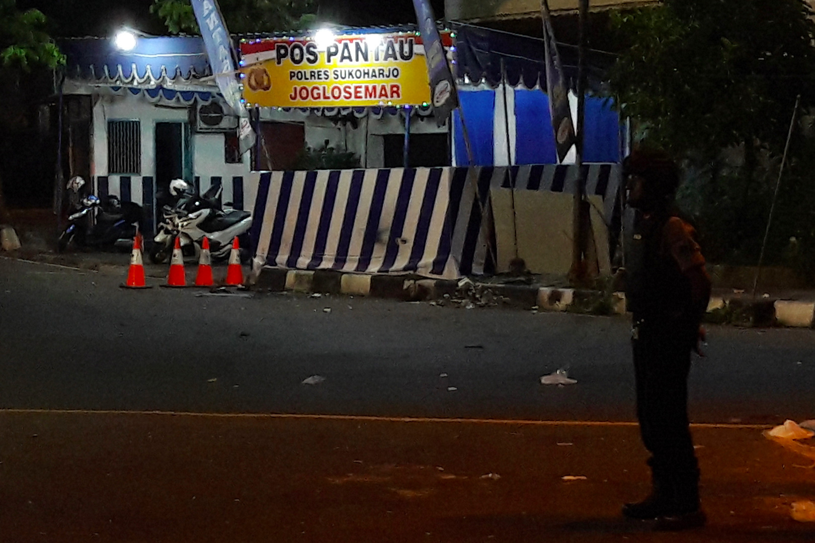  Seorang anggota kepolisian menjaga lokasi kejadian ledakan di Pos Pantau Arus Mudik Joglosemar, Kartasura, Sukoharjo, Jawa Tengah.