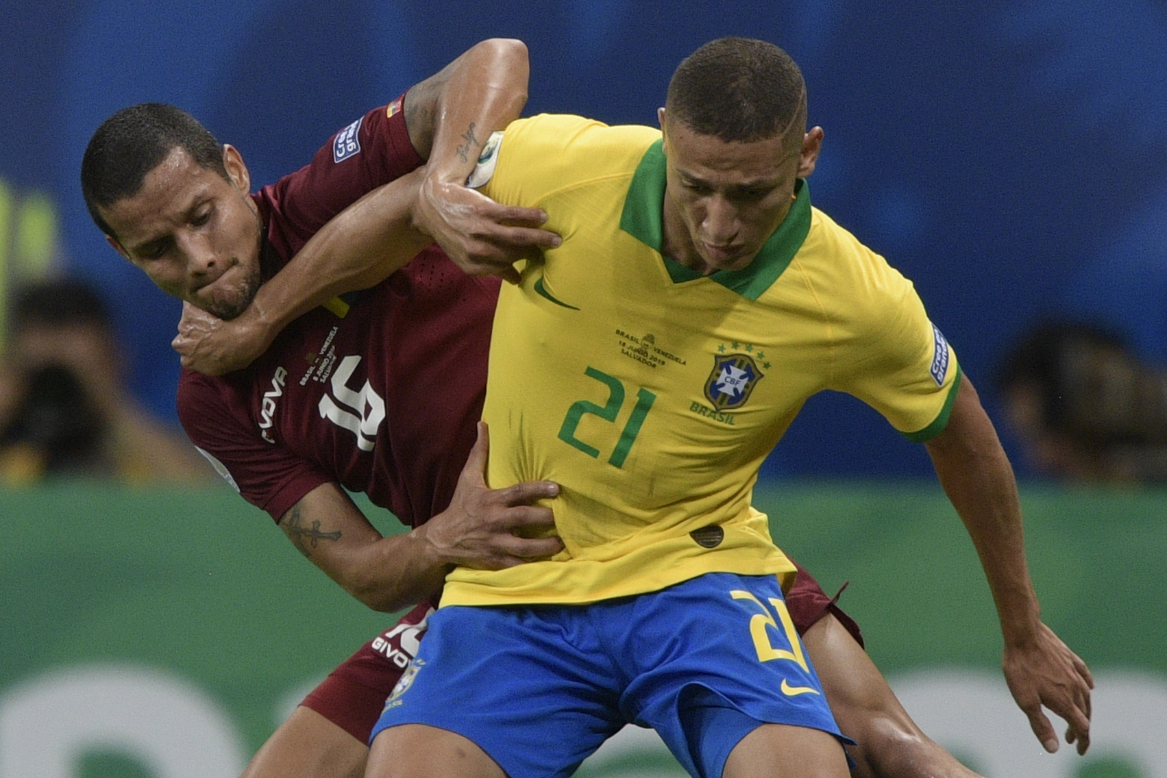Pemain dari Venezuela Roberto Rosales (kiri)  berhadapan dengan pesepakbola Brazil Richarlison dalam laga Copa America, Selasa (18/6). 