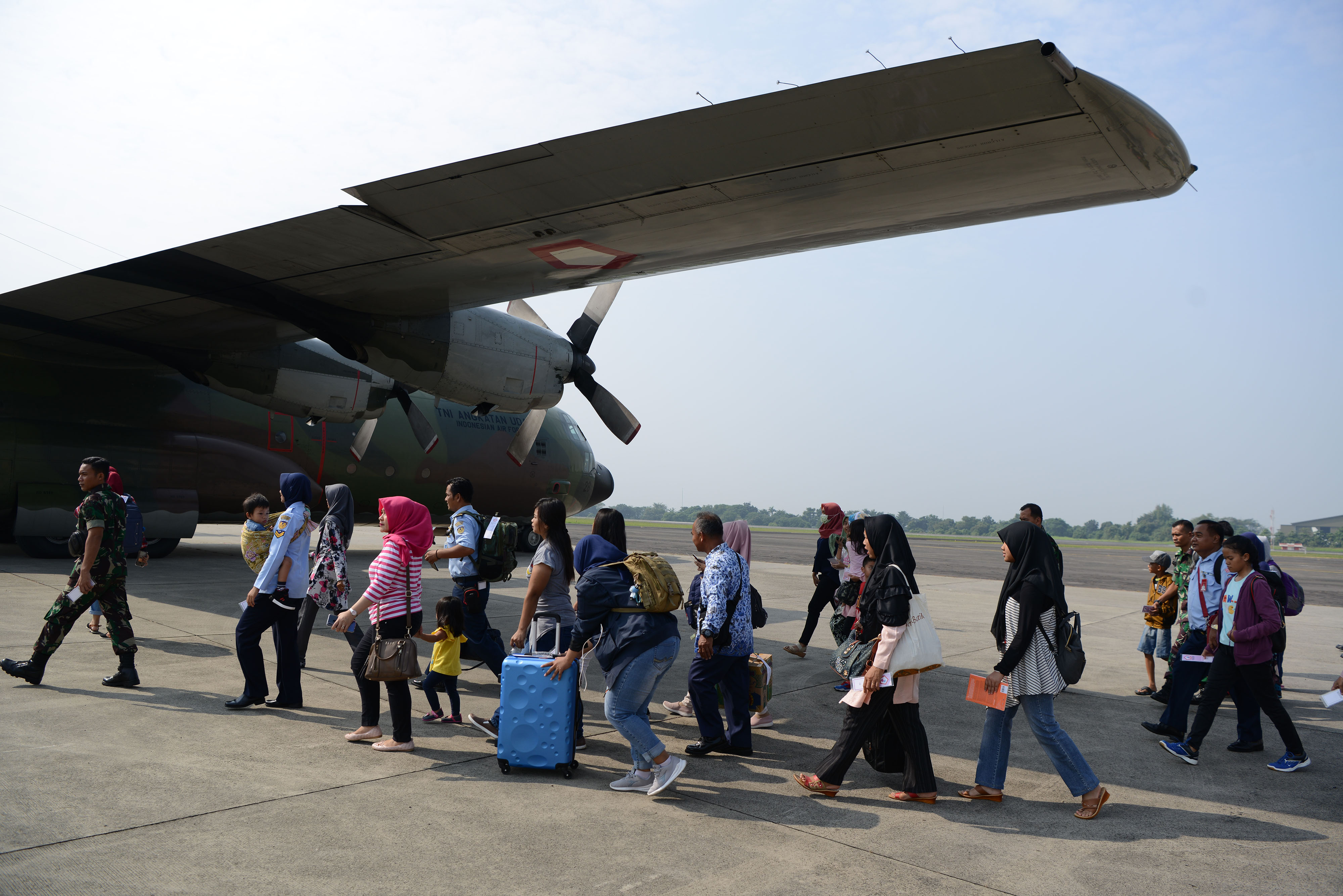 Sejumlah prajurit TNI dan keluarga berjalan menuju pesawat Hercules sesaat sebelum lepas landas di Lanud Halim Perdanakusuma.