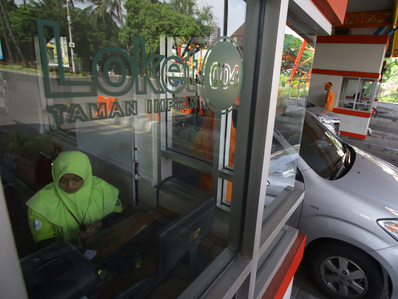  Petugas melayani mobil pengunjung yang memasuki tempat wisata Taman Impian Jaya Ancol, Jakarta.