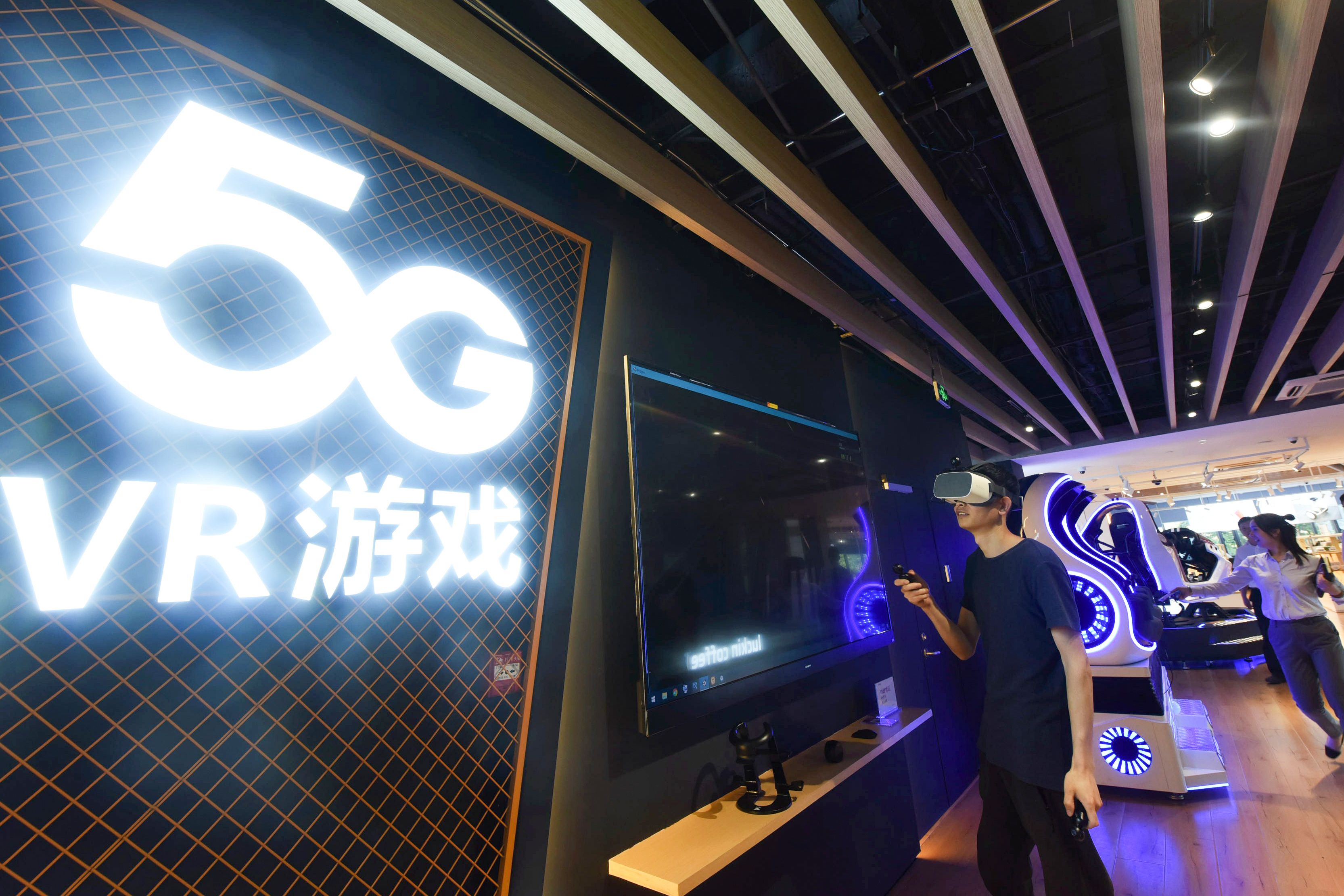Seorang pria memainkan permainan realitas virtual (VR) 5G di sebuah toko 5G di Hangzhou, provinsi Zhejiang, Tiongkok pada 3 Juni 2019.