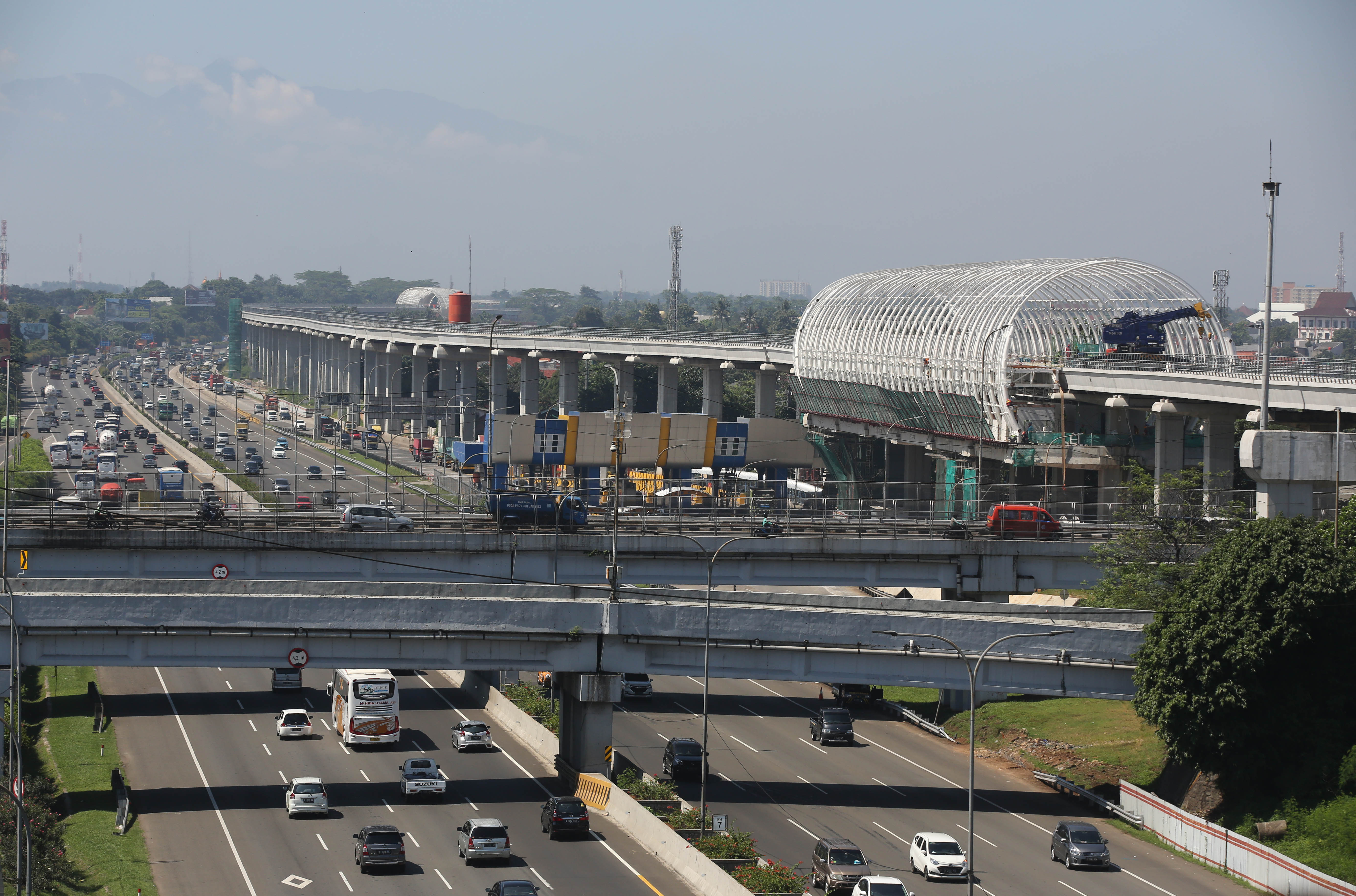 Pekerja menyelesaikan proyek pembangunan LRT yang bersebelahan dengan tol Jagorawi di kawasan Cililitan, Jakarta Timur, Jumat (29/3). 