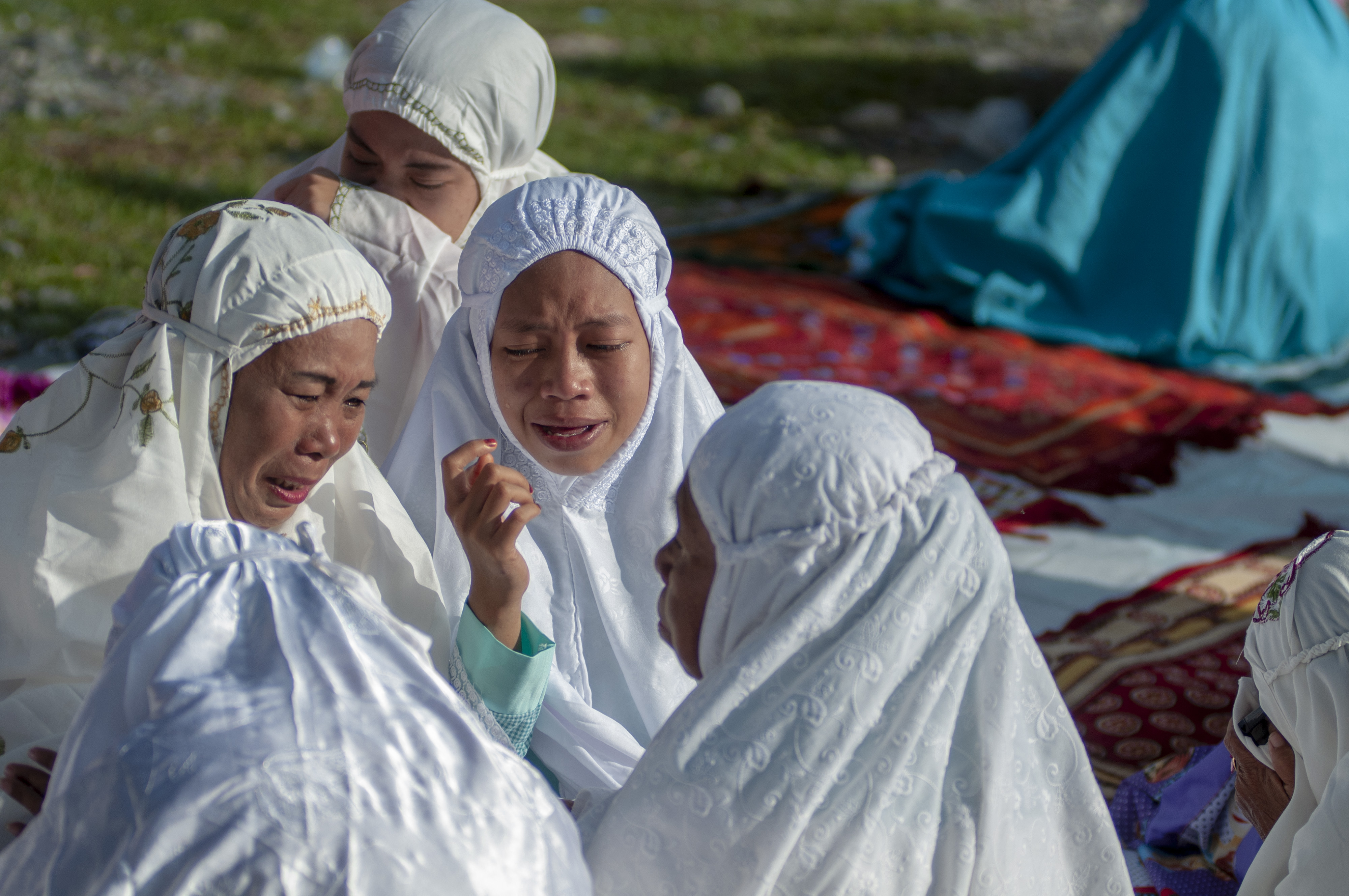 Sejumlah korban bencana terisak dan saling berpelukan usai pelaksanan salat Id di Kamp Pengungsian Balaroa, Palu, Sulawesi Tengah.