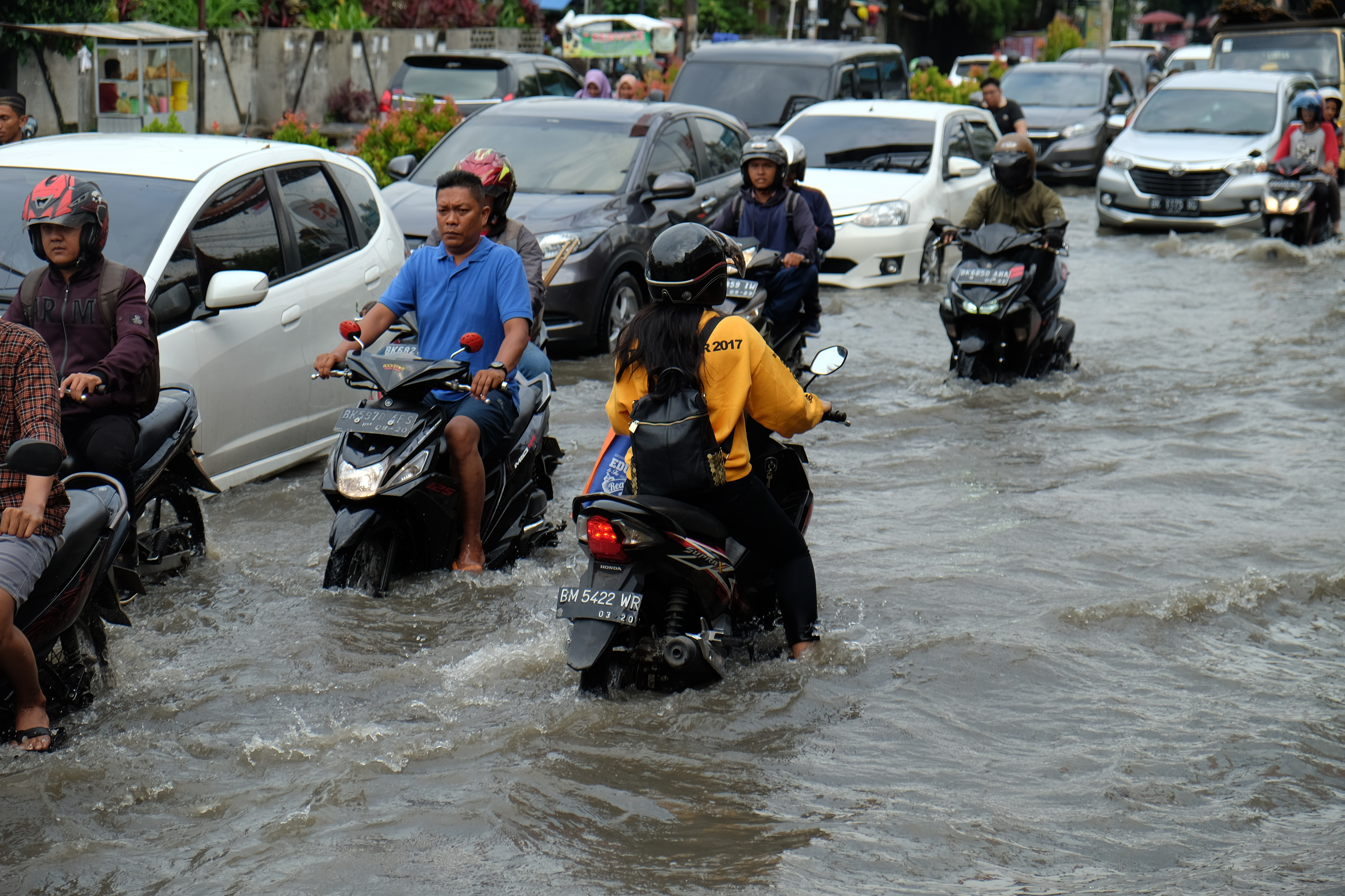 Pengendara kendaraan bermotor melintasi genangan air yang merendam kawasan Jalan dr Mansyur, Medan, Sumatra Utara, Jumat (23/11/2018).