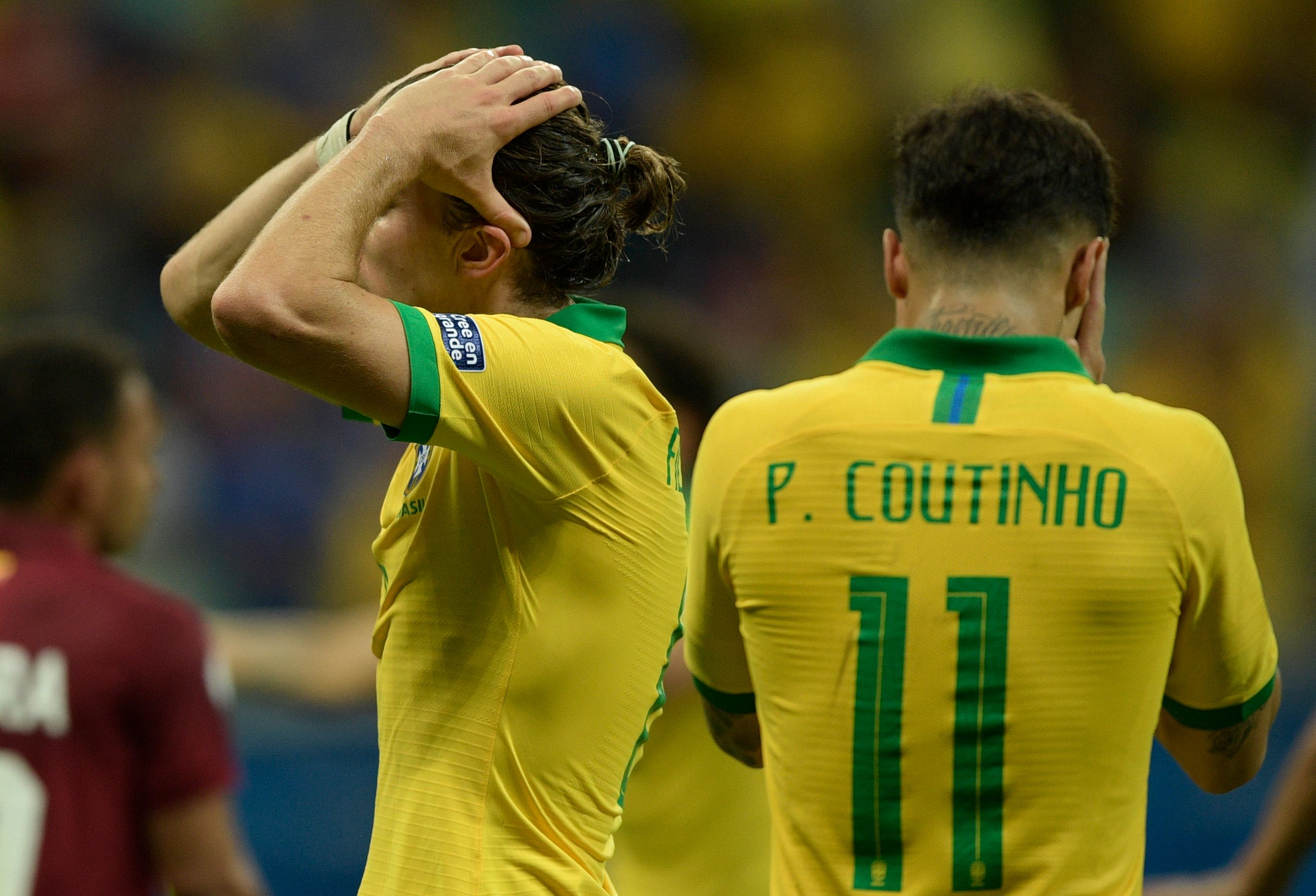 Pemain Brasil Felipe Luis (kiri) dan Philippe Coutinho bereaksi pascalaga melawan Venezuela.