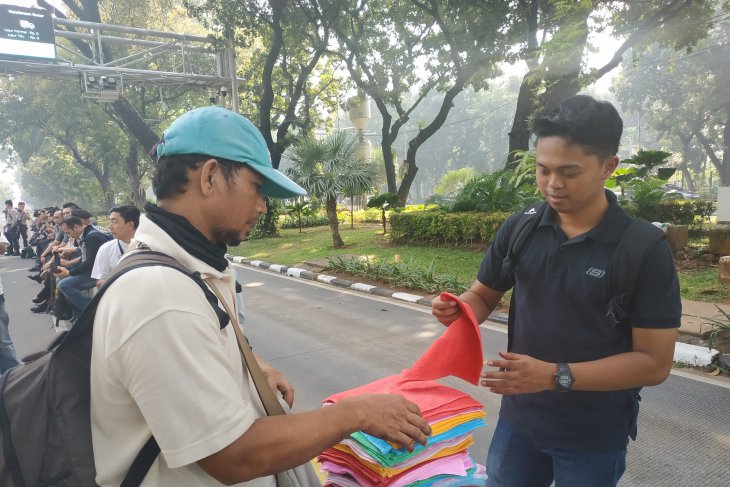 Transaksi jual beli pedagang handuk keliling di kawasan Tugu Patung Kuda Monas, Jakarta, Rabu, (26/6)