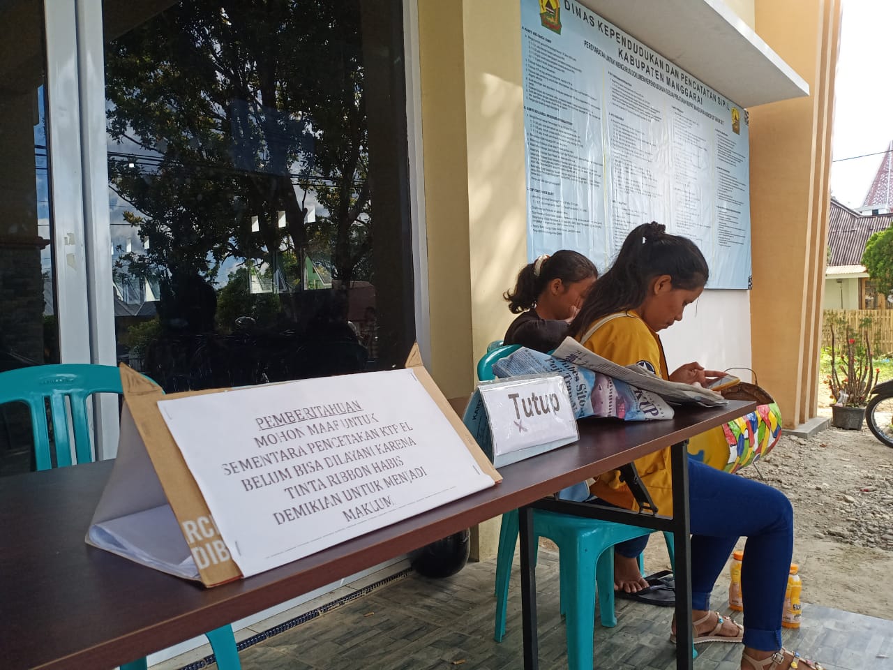 Dinas Kependudukan dan Pencatatan Sipil Kabupaten Manggarai, NTT menempelkan pemberitahuan tidak melayani pembuatan KTP-el, Rabu (19/6).
