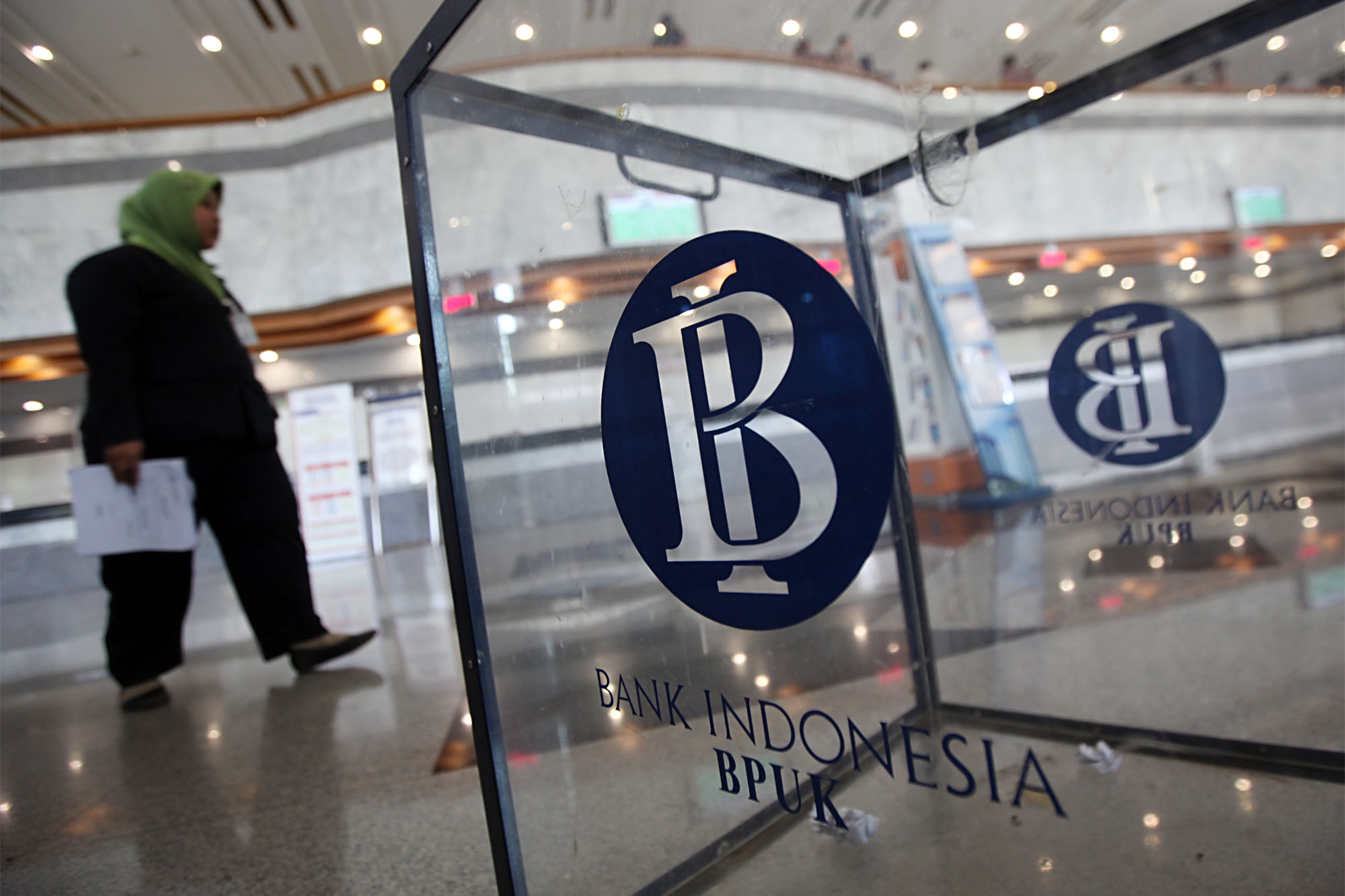 Seorang wanita melintas di dekat logo Bank Indonesia di Gedung C Bank Indonesia (BI), Jalan MH Thamrin, Jakarta Pusat