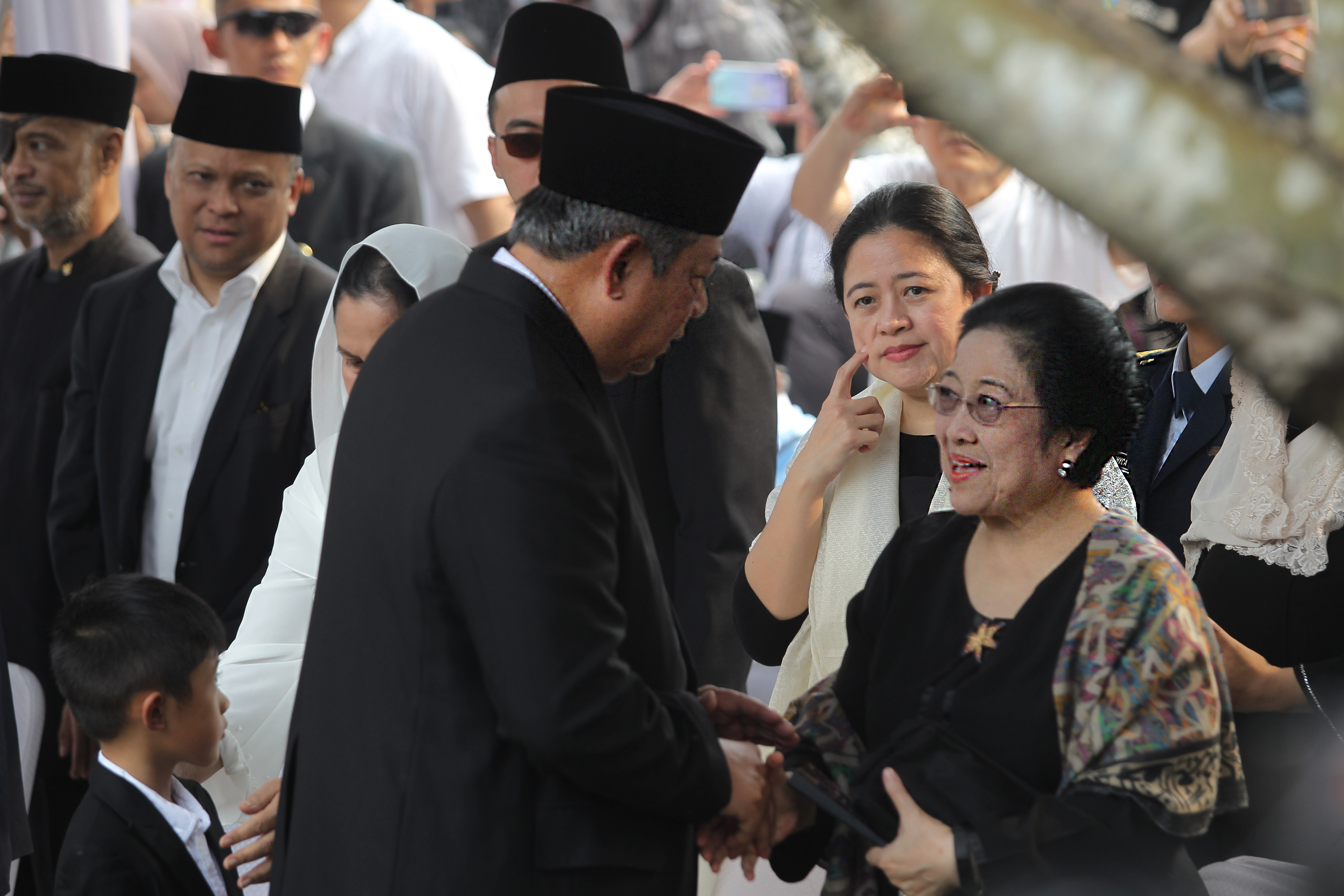 Susilo Bambang Yudhoyono (kanan) berjabat tangan dengan Megawati berjabat tangan di pemakaman Ani Yudhoyono.