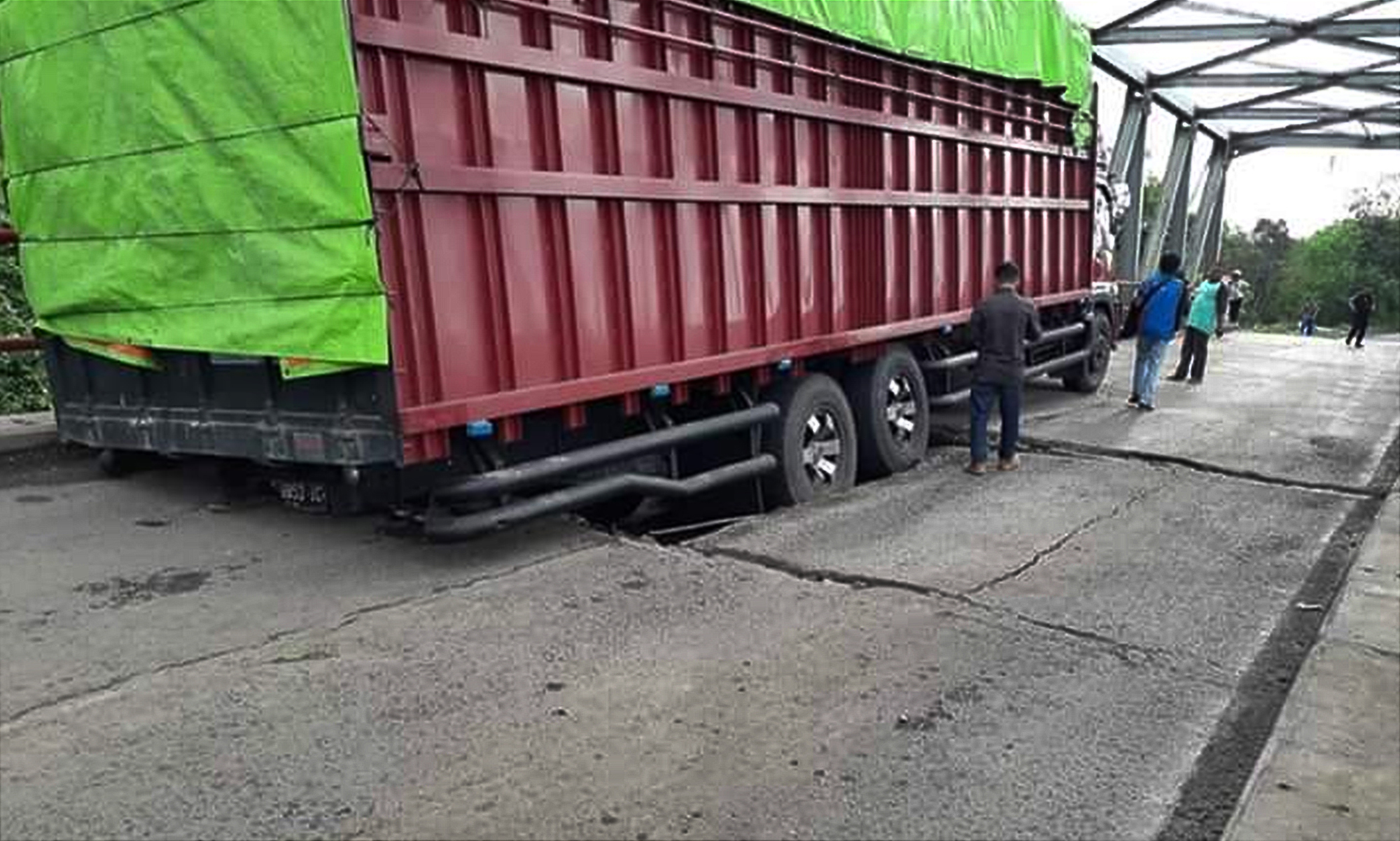  Sebuah truk sarat muatan terperosok di jembatan yang ambrol di Ogan Komering Ilir, Sumatra Selatan