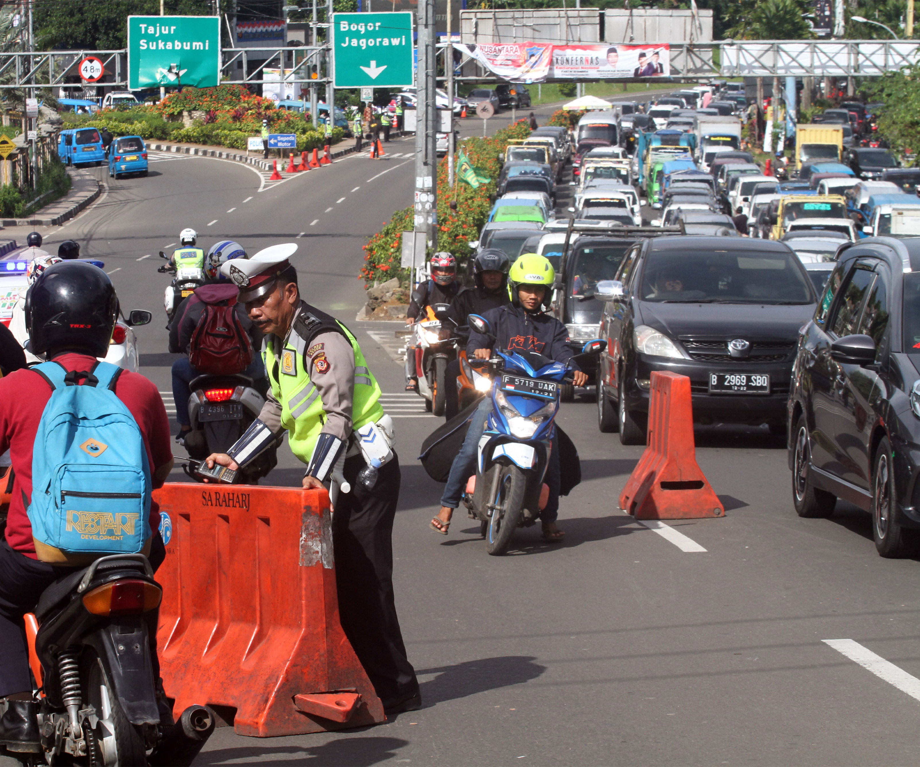 Polisi melakukan rekayasa lalu lintas untuk mengurai antrean kendaraan menuju kawasan Puncak, Gadog, Bogor, Jawa Barat.