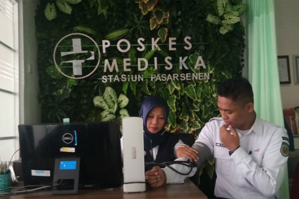 Petugas medis (kiri) memeriksa kondektur kereta di Pos Medis Stasiun Pasar Senen, Jakarta, Selasa (4/6/2019)  